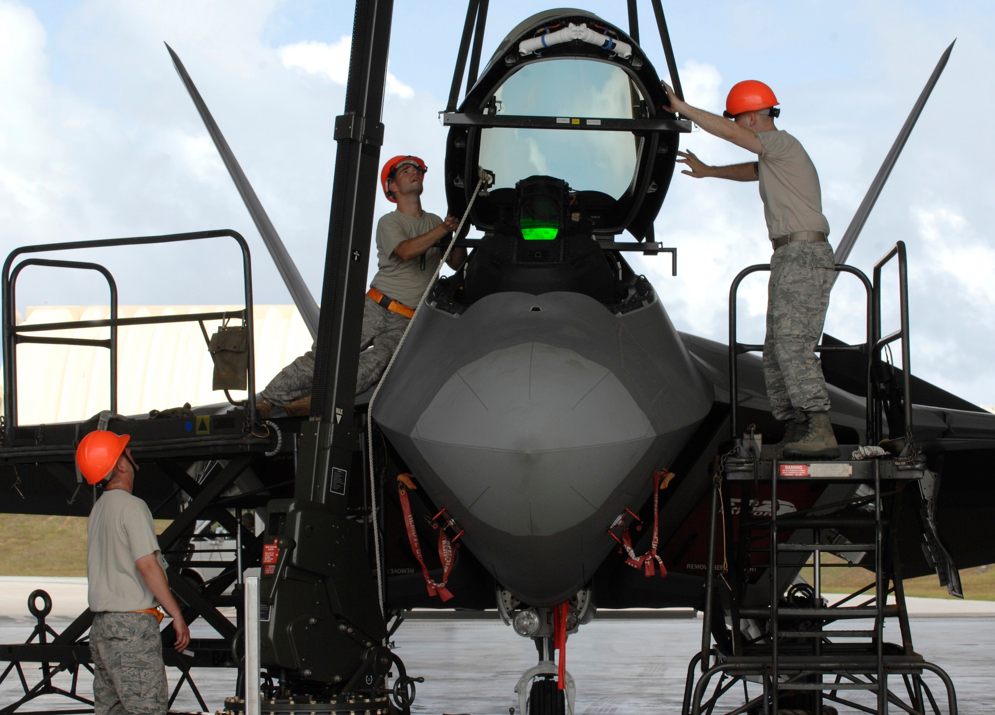 Staff Sgt. Terry Vickery, Staff Sgt. Tim Sullivan, and Senior Airman Ryan Ott, install an F-22 Raptor canopy using an east-west hoist Feb. 18 at Andersen Air Force Base, Guam. The Raptors are deployed from Elmendorf AFB, Alaska, to Guam, for three months as the Pacific's Theater Security Package. The stealth-fighters, along with associated maintenance and support personnel, comprise the 90th Fighter Squadron and will participate in various exercises that provide routine training in an environment different from their home station. All are F-22 egress and systems specialists, deployed from Elmendorf and assigned to the 36th Expeditionary Maintenance Squadron. (U.S. Air Force photo/Master Sgt. Kevin J. Gruenwald)