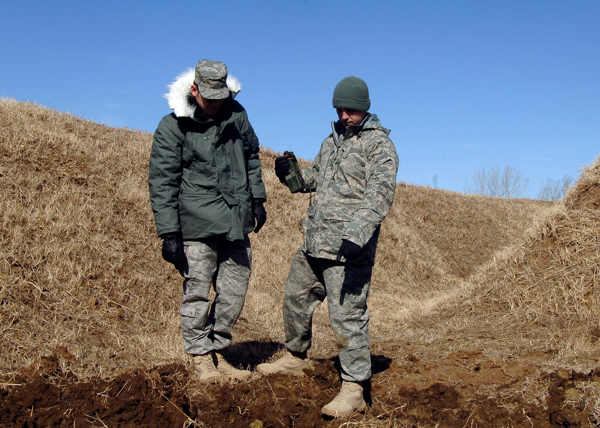 MCCONNELL AIR FORCE BASE, Kan. -- Airman 1st Class Graham Horner and Senior Airman Dwayne Ferguson 22nd Civil Engineer Squadron, explosive ordnance disposal technicians, inspect the damage site of the explosion. After the C-4 explosion, EOD technicians have to inspect it to ensure there are no fires or hazards remaining. (Photo by Senior Airman Anthony Mejia) 