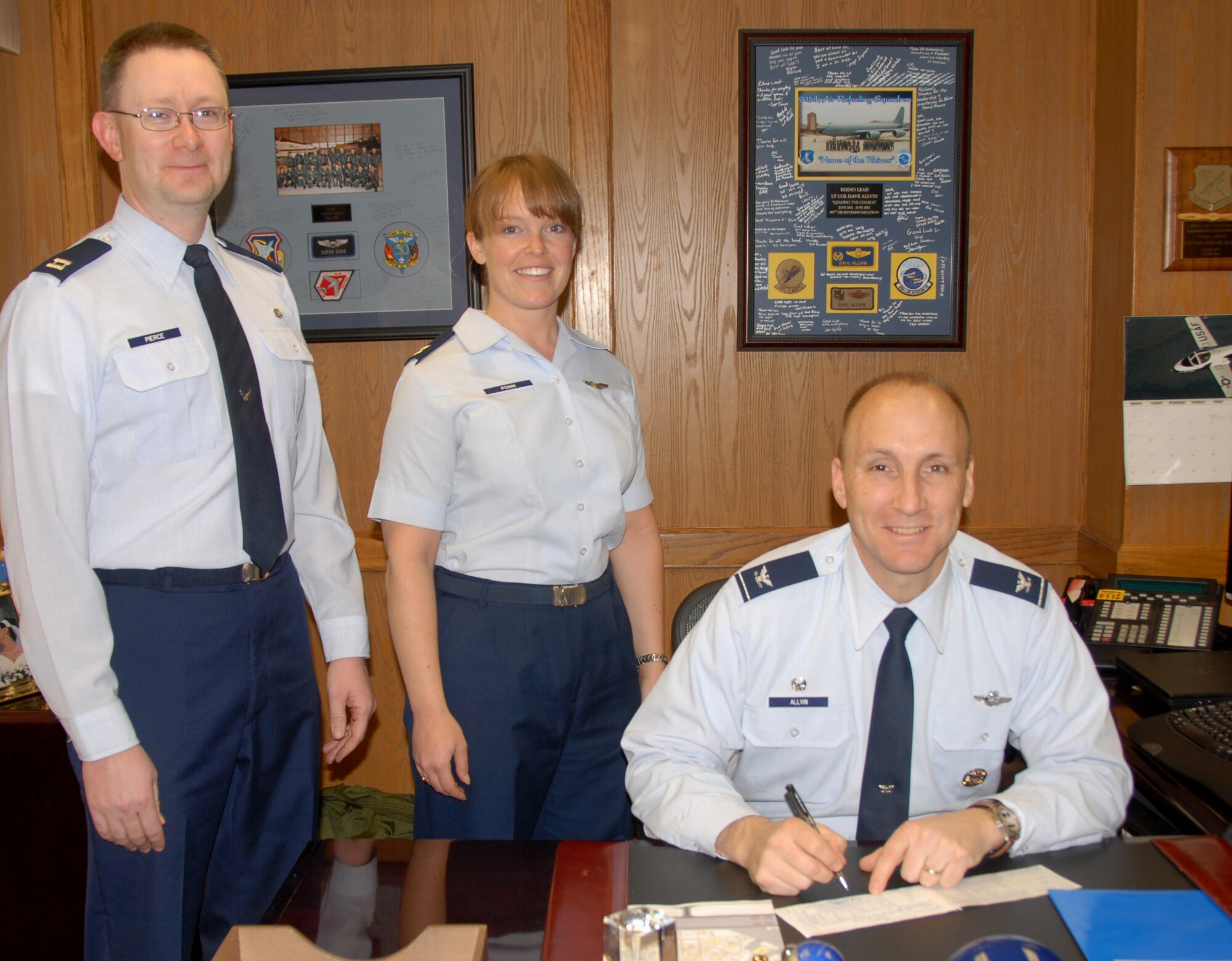 ALTUS AIR FORCE BASE, Okla. -- Col. David W. Allvin, 97th Air Mobility Wing commander, signs the Air Force Assistance Fund pledge as Capt. Abigail Ponn, the point of contact for the wing and Capt. Alex Pierce, Assistant Installation Fund Officer look on.  The AFAF was established to provide for an annual effort to raise funds for the charitable affiliates that provide support to the Air Force Family in need.  (U.S.Air Force photo/Senior Airman Jennifer L. Flores)    