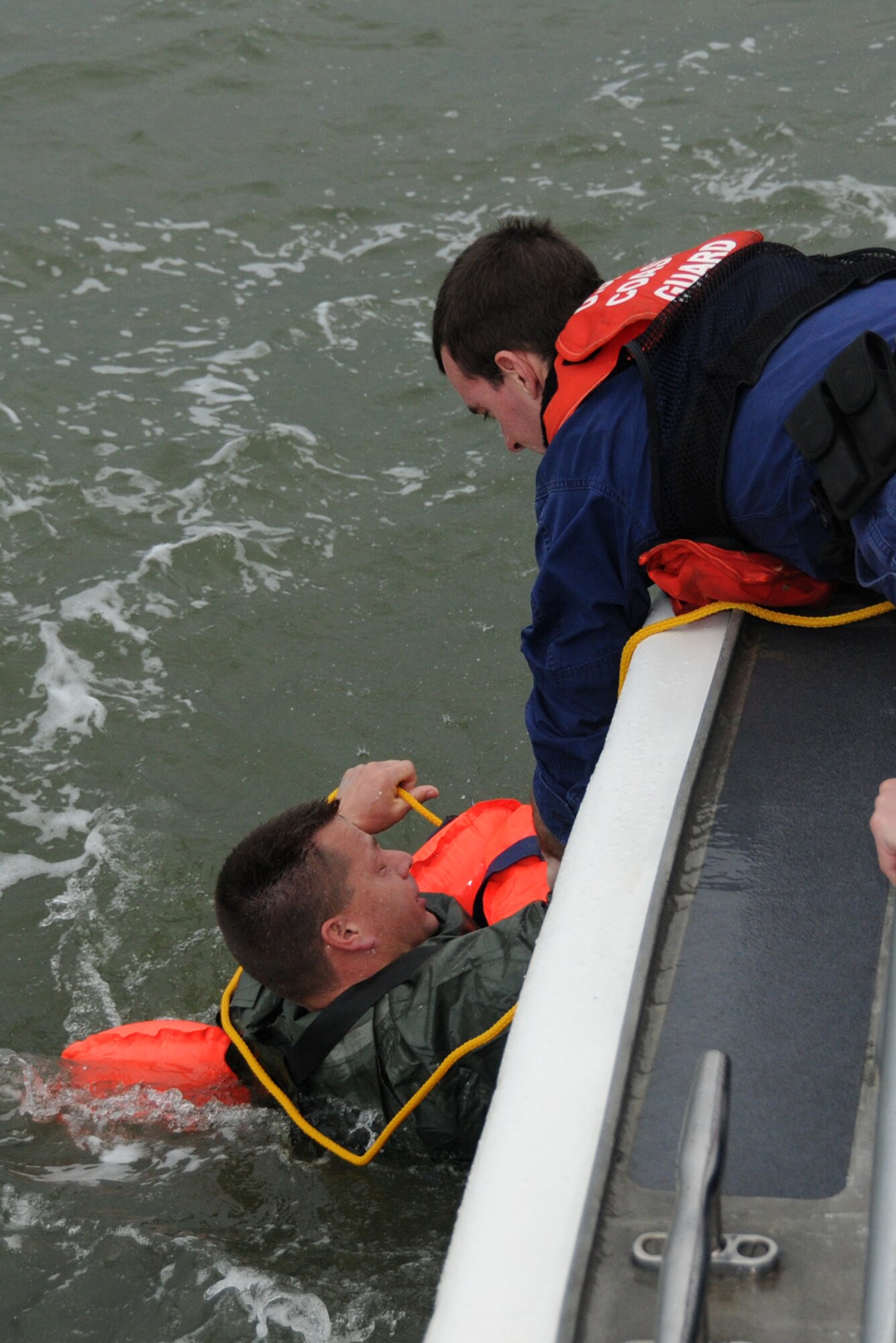Tech. Sgt. Monty Everett, 81st Training Support Squadron, is pulled from the Gulf of Mexico by Seaman Harley Watts, U.S. Coast Guard, during a plane crash exercise Feb. 18.  Sergeant Everett portrays one of the four pilots who ejected when two planes collided in the scenario.  The Department of Marine Resources also participated in the exercise, part of the preparation for Keesler’s Air Show and Open House, April 4-5.  (U.S. Air Force photo by Kemberly Groue)