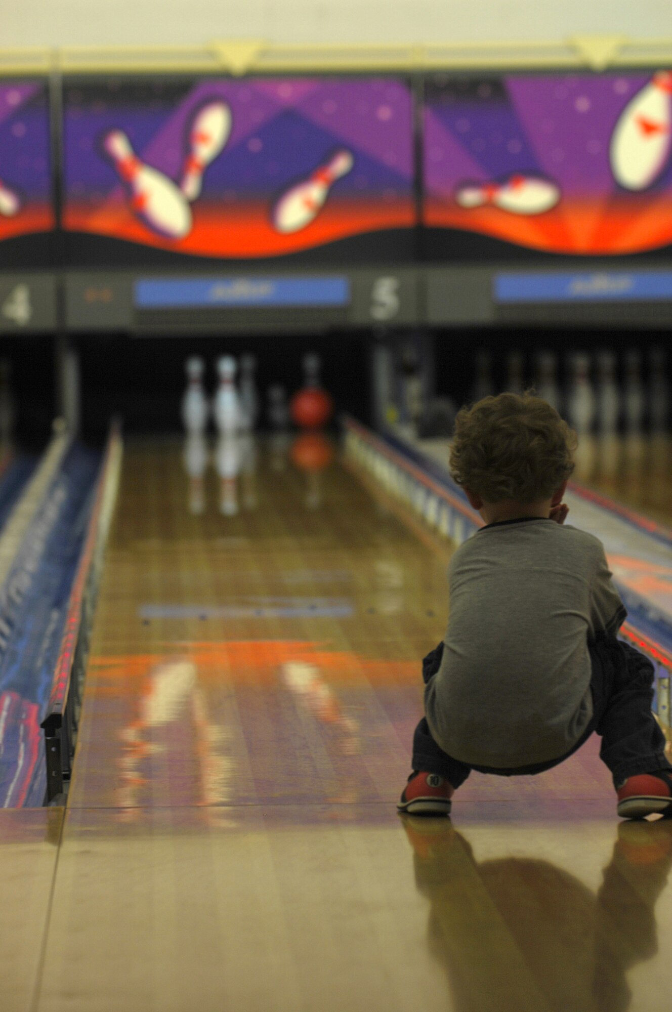 MINOT AIR FORCE BASE, N.D. -- Kellen Surrey, 3-year-old son of Maj. William Surrey, 5th Contracting Squadron, watches the pins topple during a deployed spouse’s event in the Rough Rider Lanes here recently.  The Airman and Family Readiness Center sponsors a monthly event at various locations for deployed spouses.  In addition, deployed family members can bring a copy of their sponsor’s orders to the Rough Rider Lanes and receive 3 free games on Monday's from 4 to 8 p.m., or Thursday's from 1 to 6 p.m. (U.S. Air Force photo by Tech. Sgt. Lee A. Osberry Jr.)