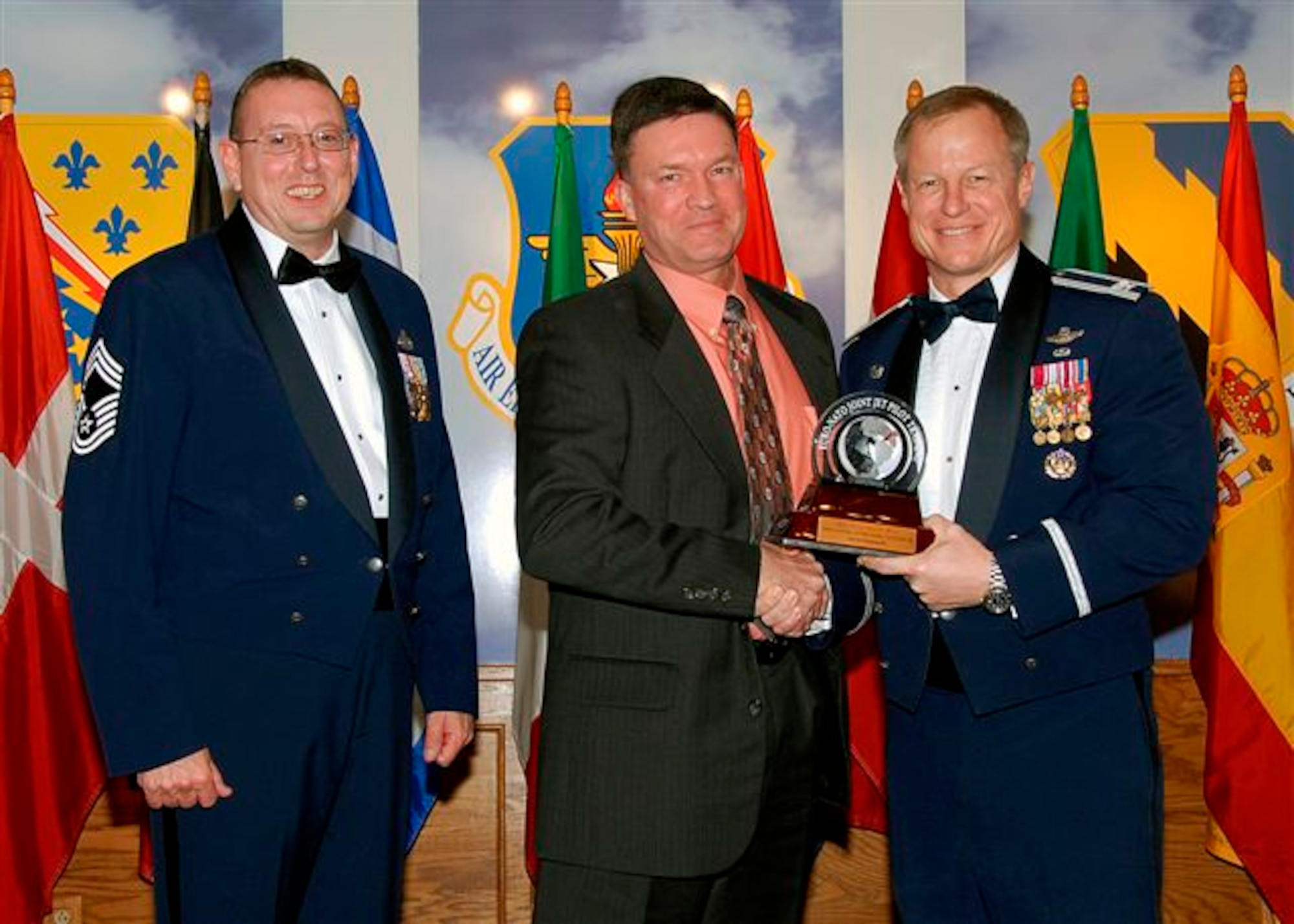 David Hudspecth, center, accepts the award as the 80th Flying Training Wing's 2008 Senior Civilian of the Year, catagory III. The 80th Operations Support Squadron air traffic controller has devoted more than 200 hours of training for more than 40 controllers enhancing their ability to control aircraft in situations where radar is unavailable.Also pictured is Col. David Petersen, 80th FTW commander, and Chief Master Sgt. Norman Thierolf, the wing's command chief. (U.S. Air Force photo) 
