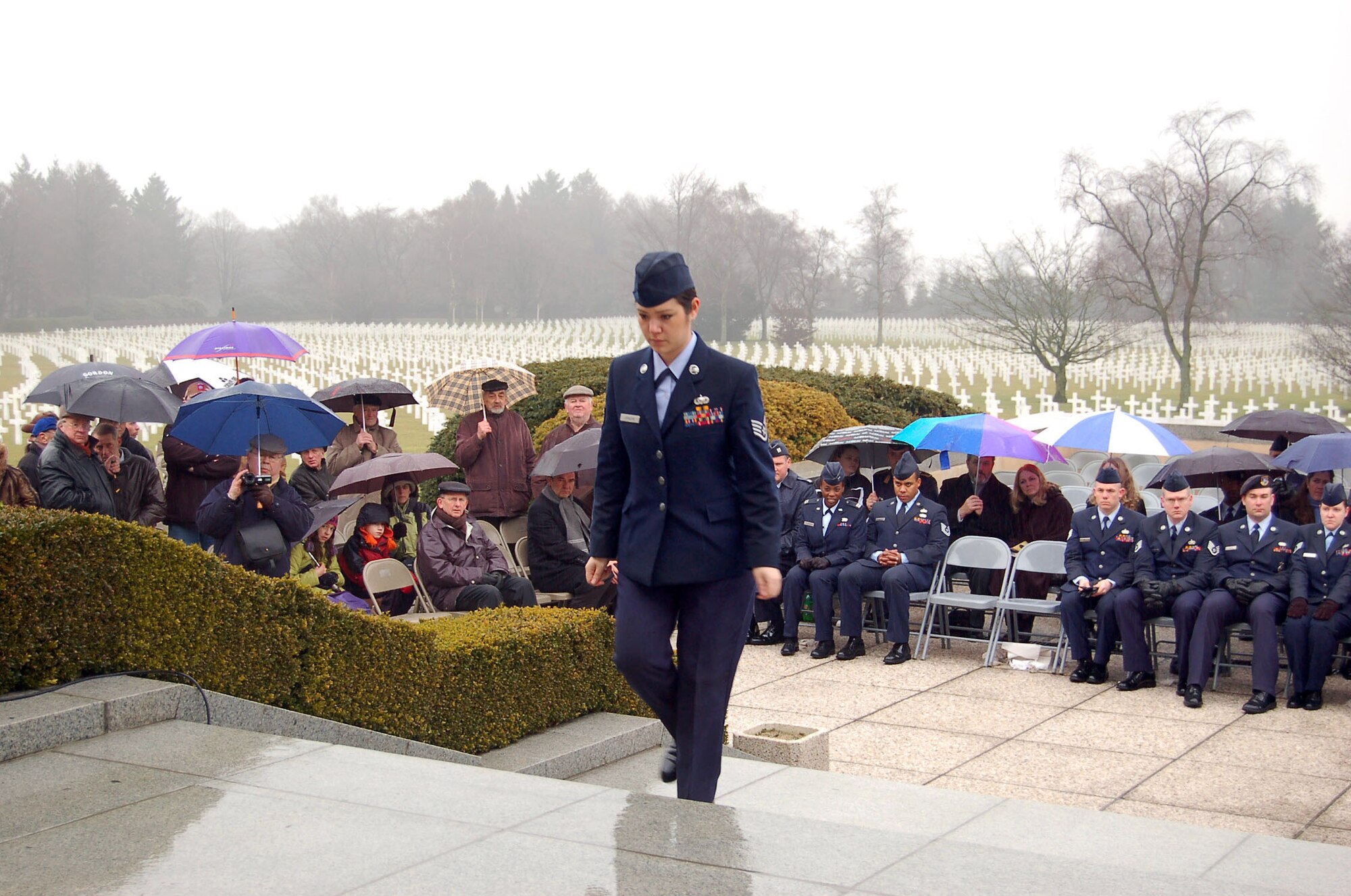 Staff Sgt. Melissa Johnson walks up the steps of the Henri-Chapelle Cemetery and Memorial Feb. 20 in Belgium during a ceremony honoring nine previously missing in action Airmen. Sergeant Johnson, who works at the NATO Programming Centre's customer service desk, placed a rosette next to Staff Sgt. Walter O. Schlosser's name, as both hail from Michigan. (U.S. Air Force photo/2nd Lt. Kathleen Polesnak) 
