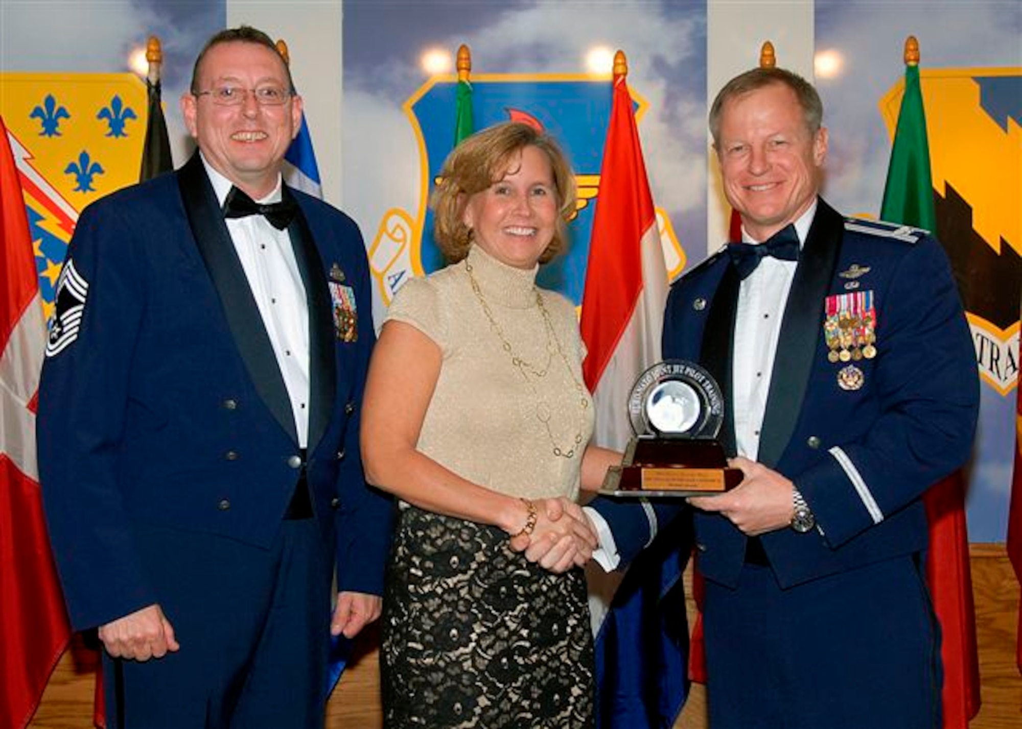 Michele Houck, center, accepts the award as the 80th Flying Training Wing's 2008 Senior Civilian of the Year, catagory II. The 80th FTW commander's secretary ensured that more than 1,200 appointments were met. She also coordinated temporary duty travel arrangements for the commander and the vice commander for 18 TDY trips to locations ranging from San Antonio, TX to Serbia. Also pictured is Col. David Petersen, 80th FTW commander, and Chief Master Sgt. Norman Thierolf, the wing's command chief. (U.S. Air Force photo) 
