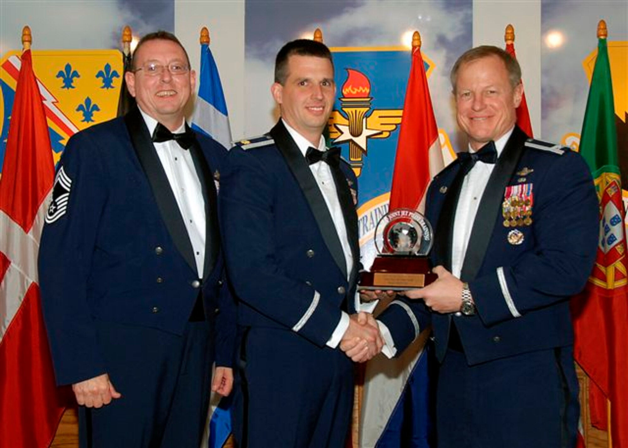 Maj. Jason Loe, center, accepts the award as the 80th Flying Training Wing's 2008 Senior Instructo Pilot of the Year. The 90th Flying Training Squadron major was recognized his role as a T-38 instructor pilot. He was selected to escort the Estonian air force Chief of Staff during NATO air chief’s visit in October 2008. Also pictured is Col. David Petersen, 80th FTW commander, and Chief Master Sgt. Norman Thierolf, the wing's command chief. (U.S. Air Force photo) 
