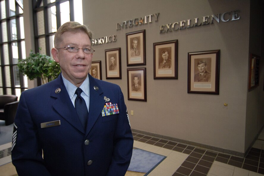 Master Sgt. Jeff Kunkle, the artist who painted the sepia-tone portraits included in the display, stands in front of the Wall of Honor, which was dedicated in a ceremony at Gunter Annex's Senior NCO Academy on Tuesday. The display honors the six enlisted Airmen who received the Medal of Honor for their actions. (Air Force photo by Melanie Rodgers Cox)