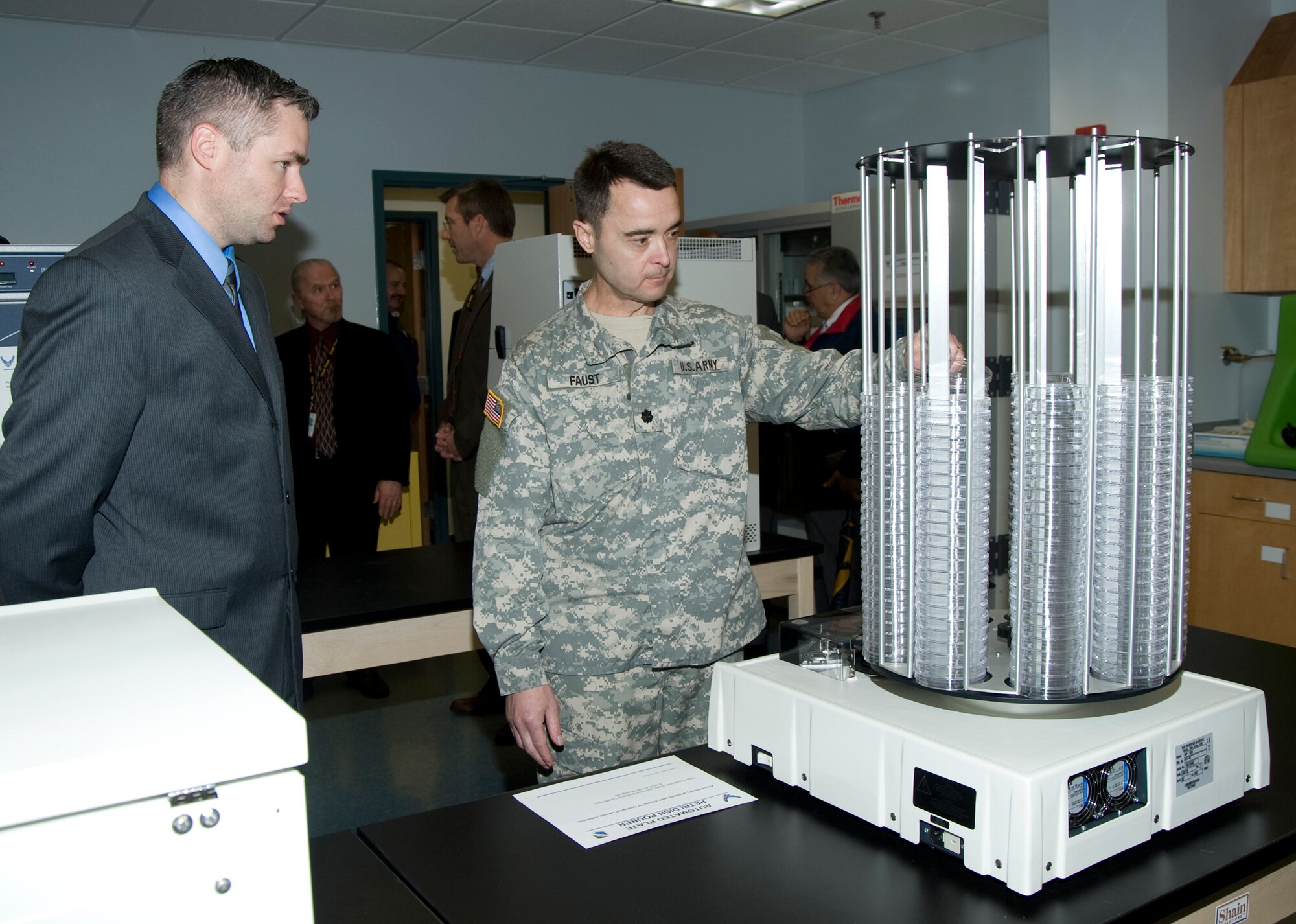 Tim Krakowski and Lt. Col. Rodney Faust, Joint Program Executive Office for Chemical and Biological Defense, inspect the automated petri dish pourer during a tour of the Dynamic Entry/Exit Test Module Feb. 18 on Eglin Air Force Base, Fla.  The DEETM underwent a major upgrade to the facility to include a new lab and ventilation system.  Courtesy photo.