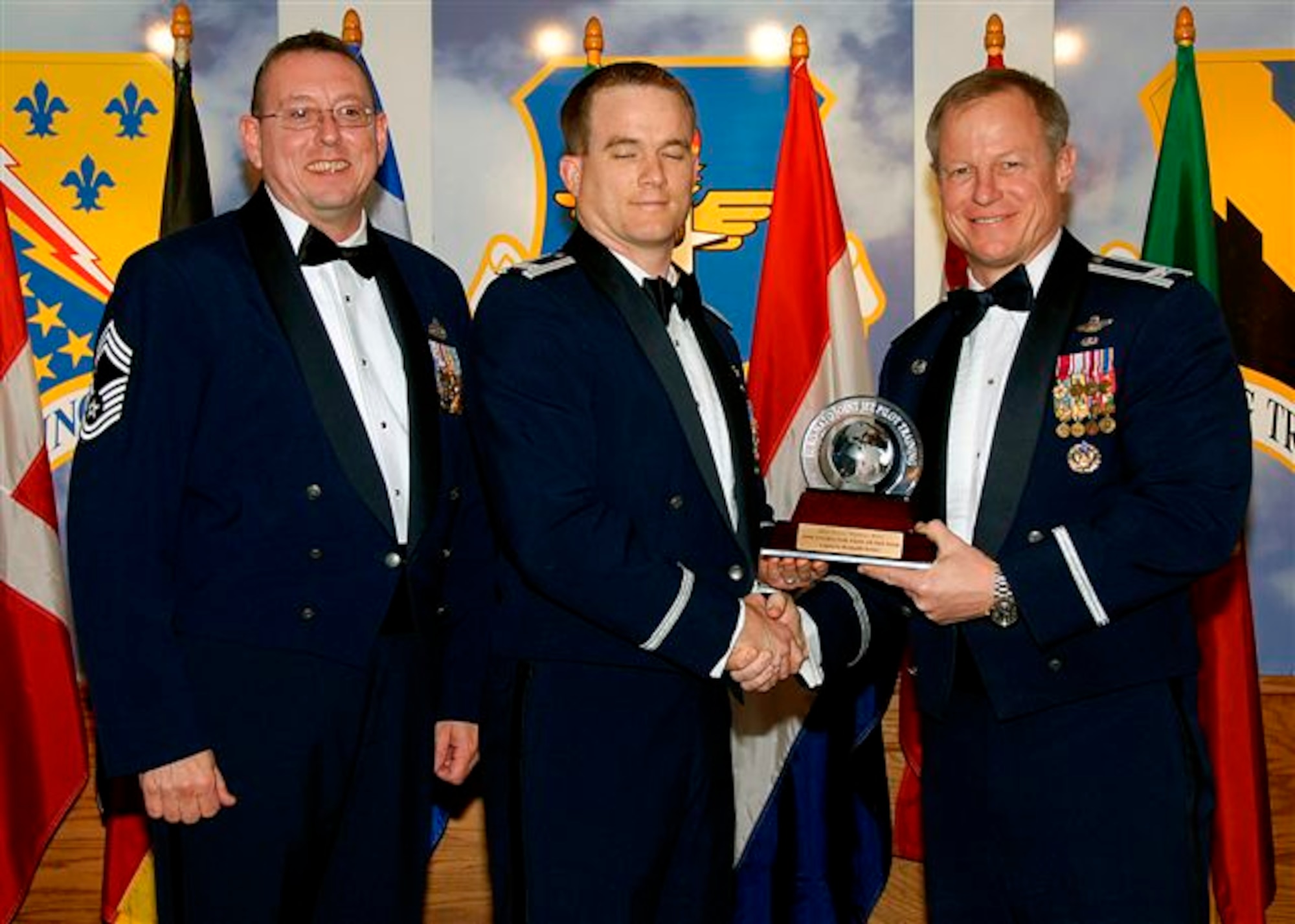Capt. Kenneth Seiver, center, accepts the award as the 80th Flying Training Wing's 2008 Senior Instructor Pilot of the Year. The 88th Fighter Training Squadron captain was recognized for role as the chief of weapons and a T-38C Introduction to Fighter Fundamentals instructor pilot. He won the Operations Group Instructor Pilot of the Month twice and was the Wing Instructor Pilot of the Quarter for January through March 2008. Also pictured is Col. David Petersen, 80th FTW commander, and Chief Master Sgt. Norman Thierolf, the wing's command chief. (U.S. Air Force photo) 