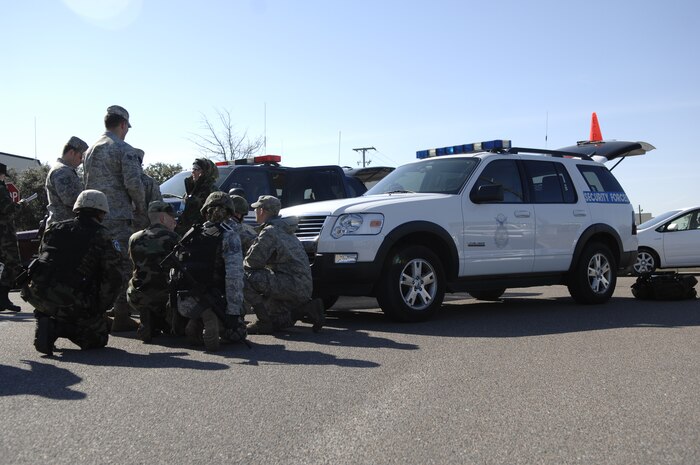 Airmen shield themselves behind security vehicles to protect themselves from an unidentified package during an exercise on Charleston AFB Feb. 23. The base conducted the exercise to test how Airmen respond to a simulated explosion caused by an improvised explosive device. (U.S. Air Force photo/Senior Airman Katie Gieratz)