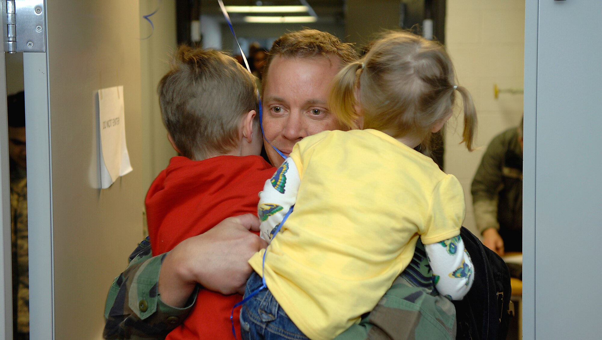 MINOT AIR FORCE BASE, N.D. -- Master Sgt. Frank Cowper, 5th Aircraft Maintenance Squadron production manager, embraces his children upon his return here Feb. 23 from Andersen AFB, Guam. The 5th Bomb Wing sent six B-52H Stratofortresses and more than 200 personnel to provide a continuous bomber presence in U.S. Pacific Command. (U.S. Air Force photo by Airman 1st Class Benjamin Stratton)