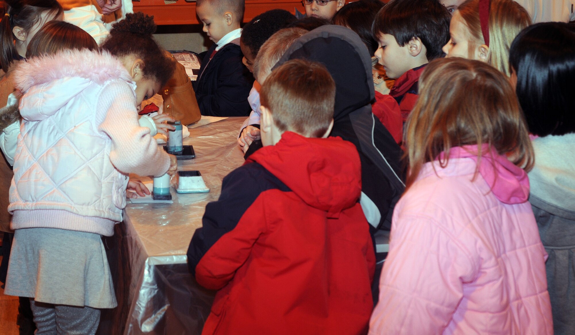 Children from three Lakenheath Elementary School kindergarten classes gather around a desk to stamp surprise letters they wrote for their parents at the RAF Lakenheath Post Office Feb. 20. While at the post office, the children learned how the postal service works here. (U.S. Air Force photo by Senior Airman Kristopher Levasseur)