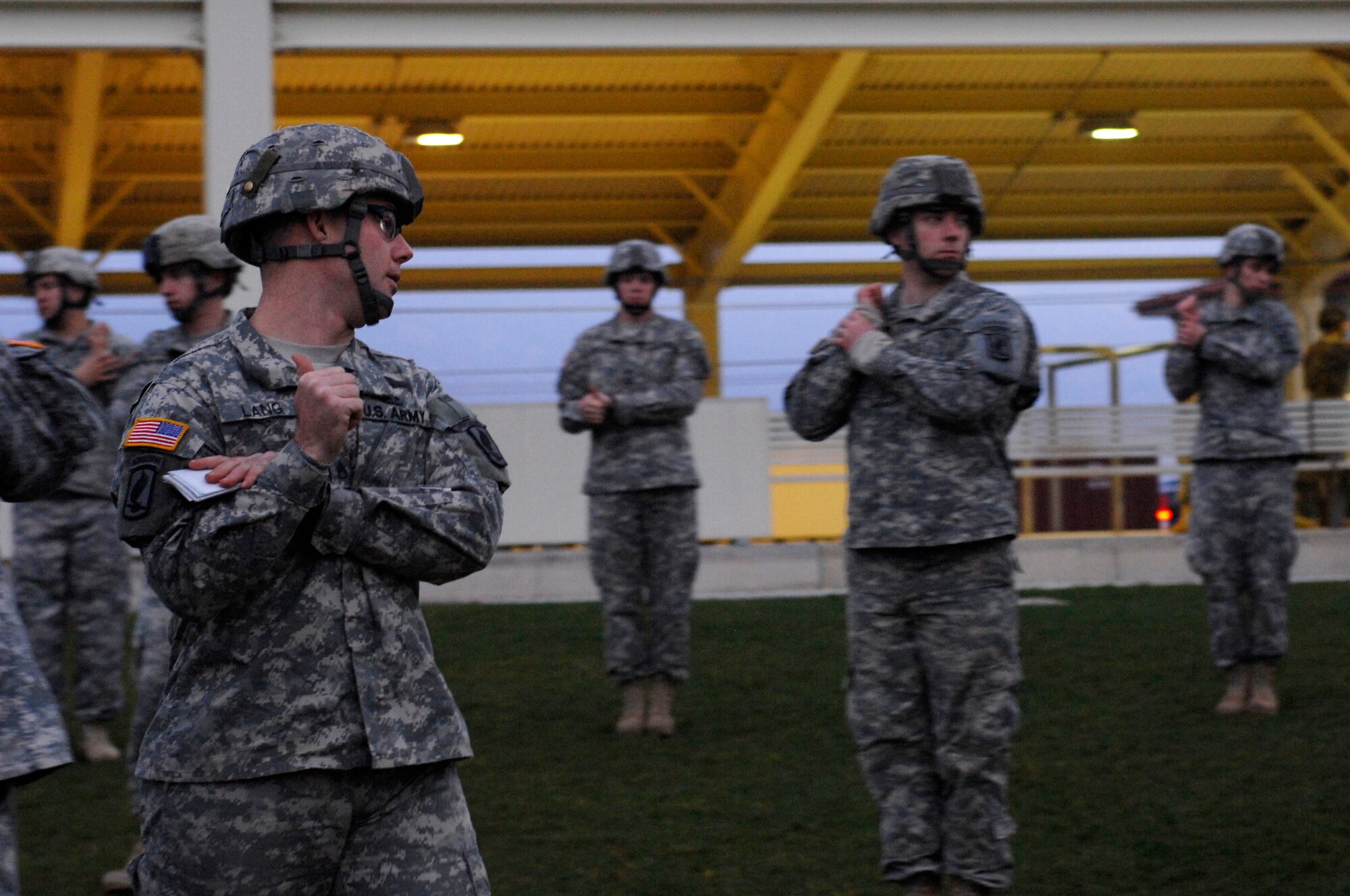 AVIANO AIR BASE, Italy:  Jumpmaster students from the 173rd Airborne Brigade train how to release the canopy release mechanism on a parachute Feb. 10 outside the Personnel Alert Holding Area on Area F.  The mechanism allows Soldiers to recover from being dragged by an inflated parachute once they land on the ground.  The thumb is used to activate the canopy release and the arm is used to help the jumper pull down hard to prevent being dragged.  (U.S. Air Force photo/Airman 1st Class Ashley Wood)   