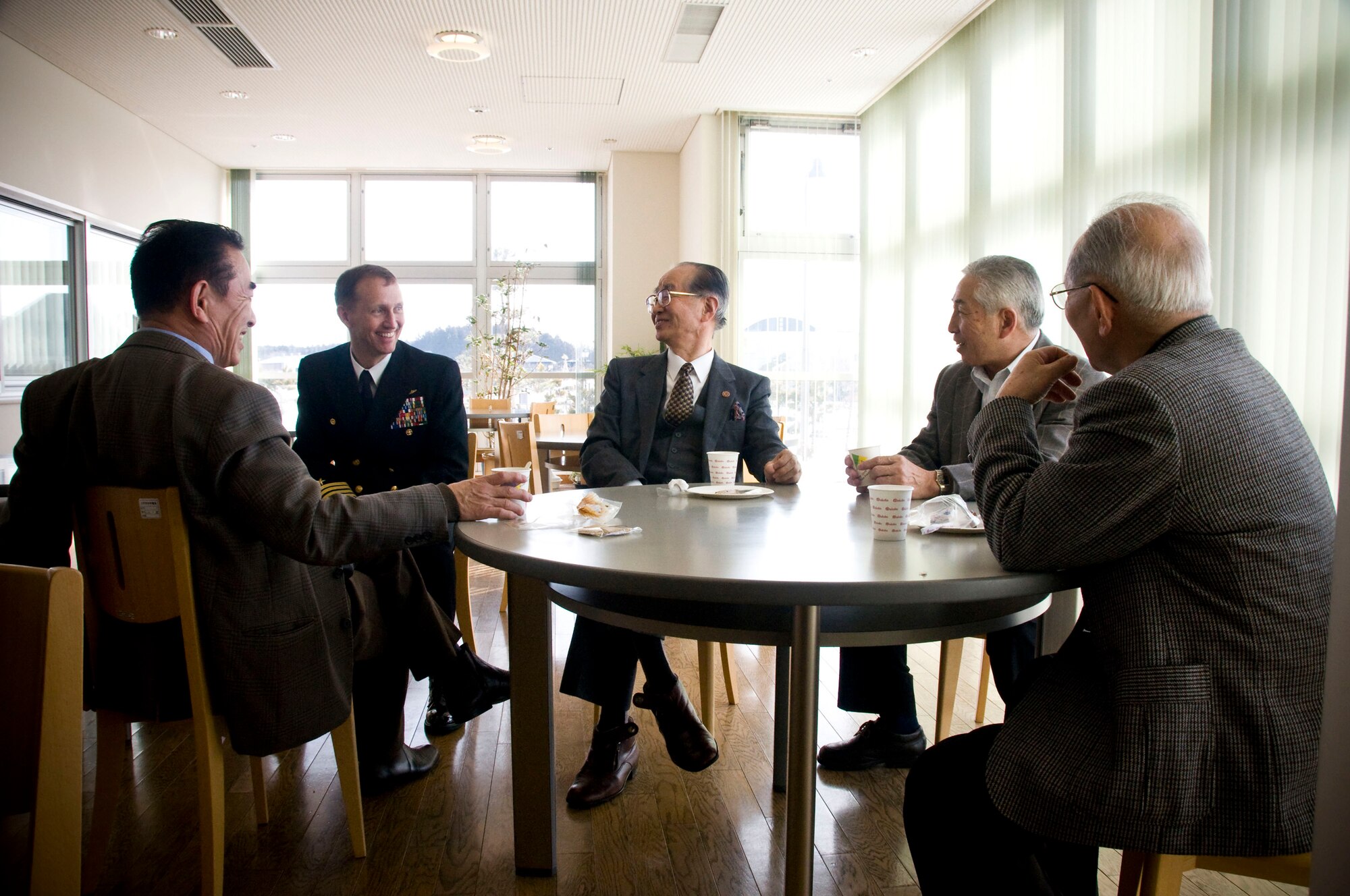 MISAWA CITY, Japan -- Navy Capt. James Haugen, Naval Air Facility Misawa commanding officer, socializes with Japanese businessmen following the annual Misawa Air Base Red Feather Campaign check presentation ceremony at the Misawa International Center Feb. 23, 2009. Following the ceremony, representatives of the various contributing agencies to the Red Feather Campaign had a chance to meet and talk to the Japanese attendees over refreshments. (U.S. Air Force photo by Staff Sgt. Samuel Morse)