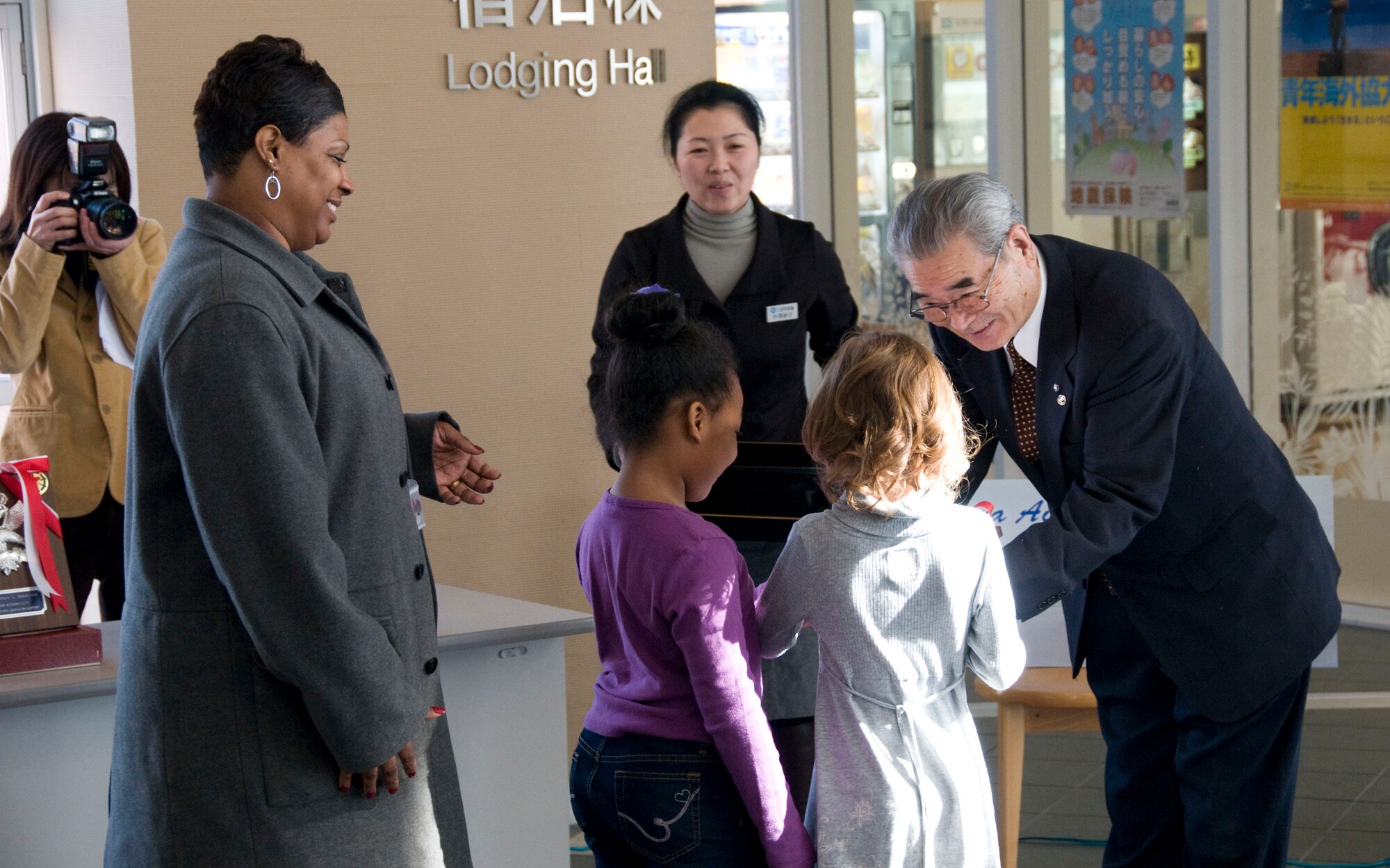 MISAWA CITY, Japan -- Ishi Numata, Misawa Red Feather Fund Committee president, gives a plaque to representatives of Cummings Elementary School at the Misawa International Center Feb. 23, 2009. Cummings Elementary School raised $370 of the more than $8,000 donation to the Misawa Red Feather Community Chest. (U.S. Air Force photo by Staff Sgt. Samuel Morse)