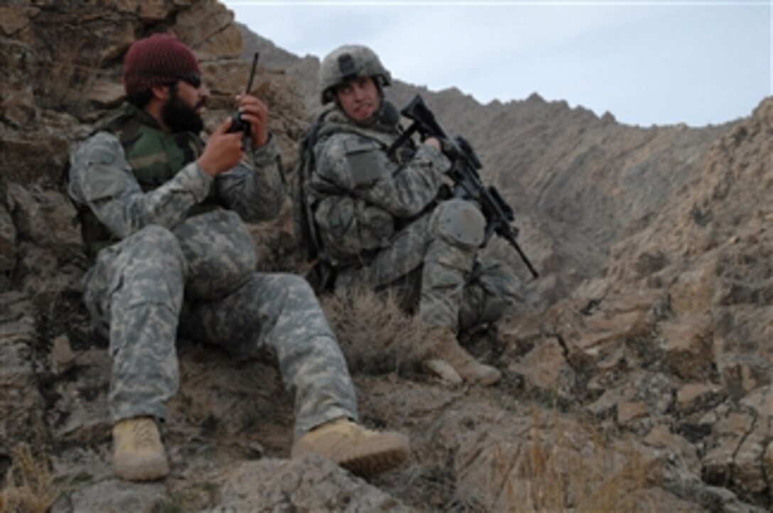 U.S. Army 1st Lt. Jared Tomberlin (right) from Bravo Company, 1st Battalion, 4th Infantry Regiment, United States Army Europe pauses for a moment to speak with his interpreter Abraham while on dismounted patrol on top of a mountain ridge near Forward Operation Base Lane, Zabul Province, Afghanistan, on Feb. 21, 2009.  