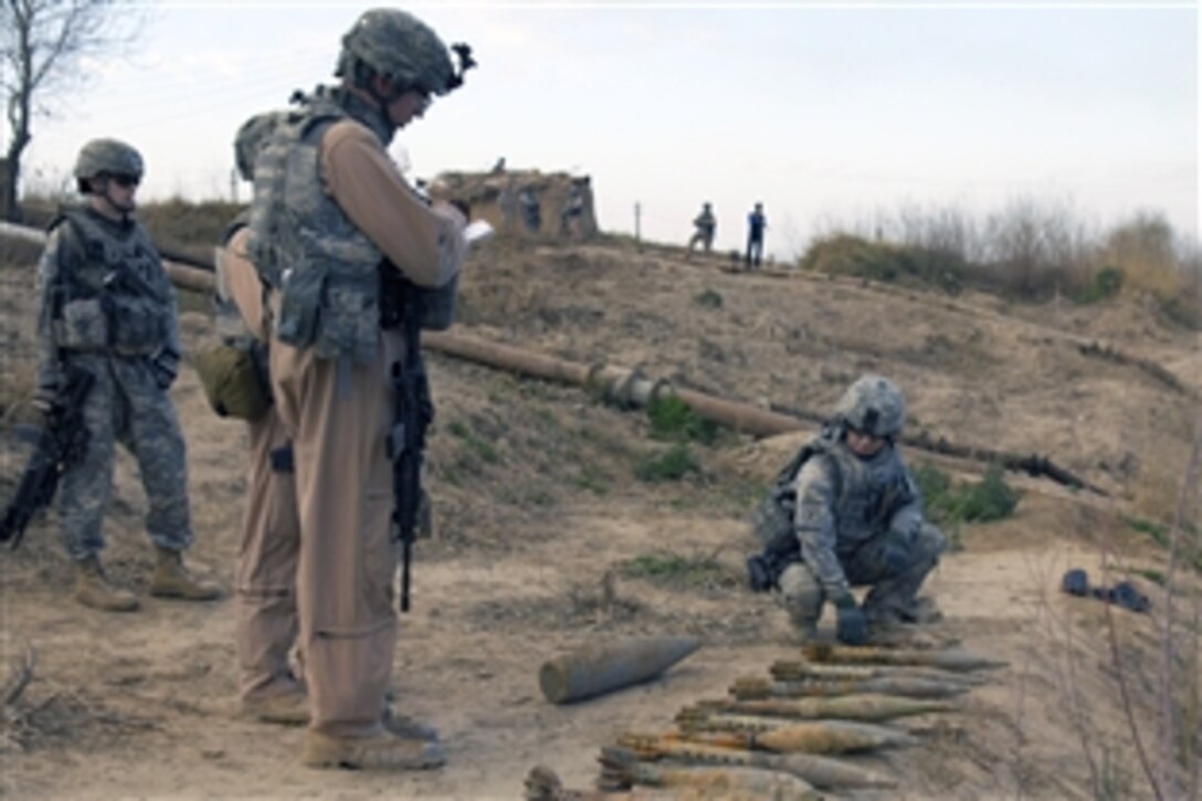 U.S. Army Staff Sgt. Tasia Richards, right, examines munitions found on a river bank in the Arab Jabour district of Baghdad, Iraq, Feb. 16, 2009. Richards is assigned to the 752nd Explosive Ordnance Disposal Company.