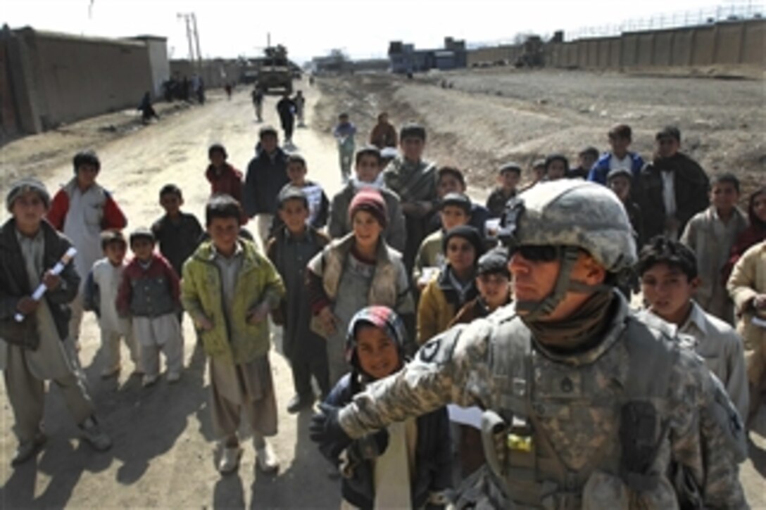 U.S. Army Staff Sgt. Peter Tyo holds local children back as a convoy prepares to leave after a mission into Gardez City, Afghanistan, in Paktia province, Feb. 11, 2009. The children typically follow the convoy, looking for candy, pens or other handouts. Tyo is assigned to 1st Battalion, 178th Infantry Regiment. 
