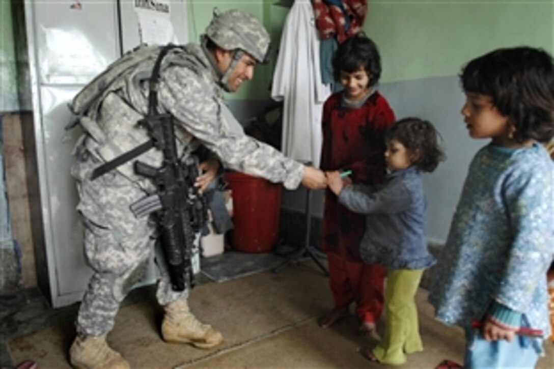 U.S. Army Sgt. Heriberto Medina gives a pen to a little girl at the hospital in Paktia province, Afghanistan, Feb. 17, 2009, during a stop there by the provincial reconstruction team. Medina, assigned to the 1st Battalion, 178th Infantry Regiment, is part of a unit that usually carries pens and candy to give to children. 