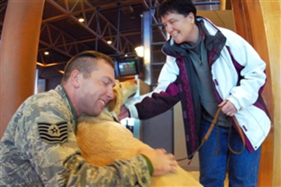 U.S. Air Force Tech. Sgt. Terry Moser greets his wife and dog upon arriving at Hector International Airport in Fargo, N.D., Feb. 23, 2009. Moser, assigned to the 119th Services Flight with the North Dakota Air National Guard, returned from a deployment in Iraq.