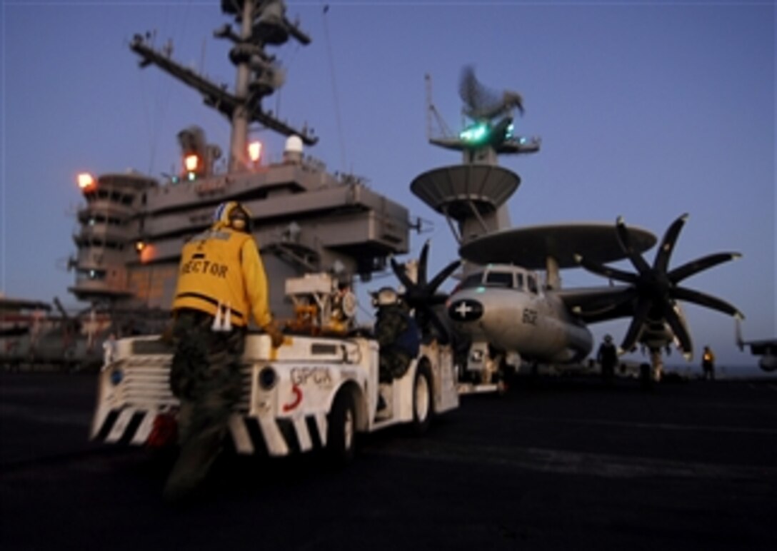 U.S. Navy Petty Officer 2nd Class Jose Rodriguez-Gonzalez (left) guides an E-2C Hawkeye aircraft assigned to Carrier Airborne Early Warning Squadron 112 into position on the flight deck of the aircraft carrier USS John C. Stennis (CVN 74) while the ship is underway in the Pacific Ocean on Feb. 22, 2009.  The Stennis and Carrier Air Wing 9 are on a six-month deployment to the western Pacific Ocean.  