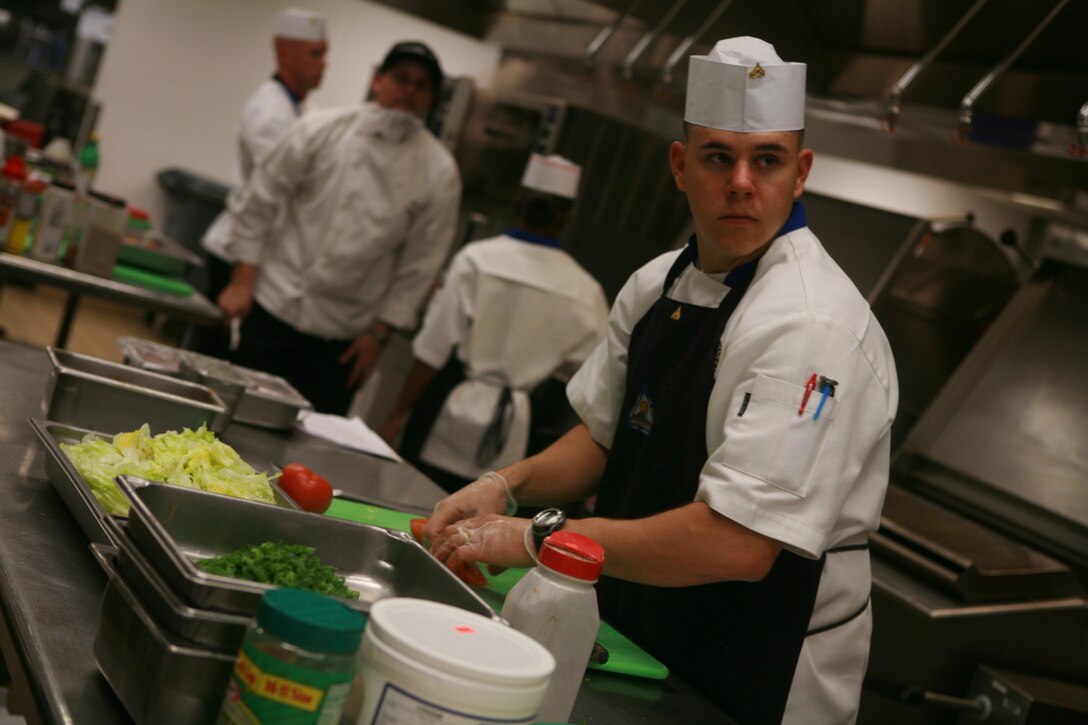 Cpl. Jacob R. Ballard, 21, Coventry, Rhode Island, a food service specialist from Marine Corps Air Station Yuma, chops tomatoes at the Culinary Team of the Quarter Competition here Feb. 25. The competition had a Mardi Gras celebration theme and each team had to prepare a full-course meal while maintaining that theme. The winners were awarded embroidered chef?s coats, gold medals, a plaque and a two-week trip to the Culinary Institute of America in New York. Marine Corps Air Station Yuma?s team came in first place and the team from Marine Corps Air Ground Combat Center Twentynine Palms came in second.