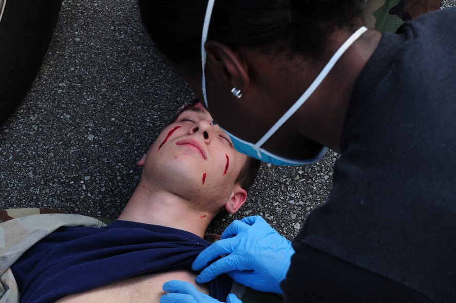 An 18th Wing paramedic cares for a simulated accident victim, Airmen 1st Class Judd Gregg, on Kadena Feb. 26. The emergency management exercise honed Kadena's response capabilities. (U.S. Air Force photo/Airman 1st Class Amanda Grabiec)