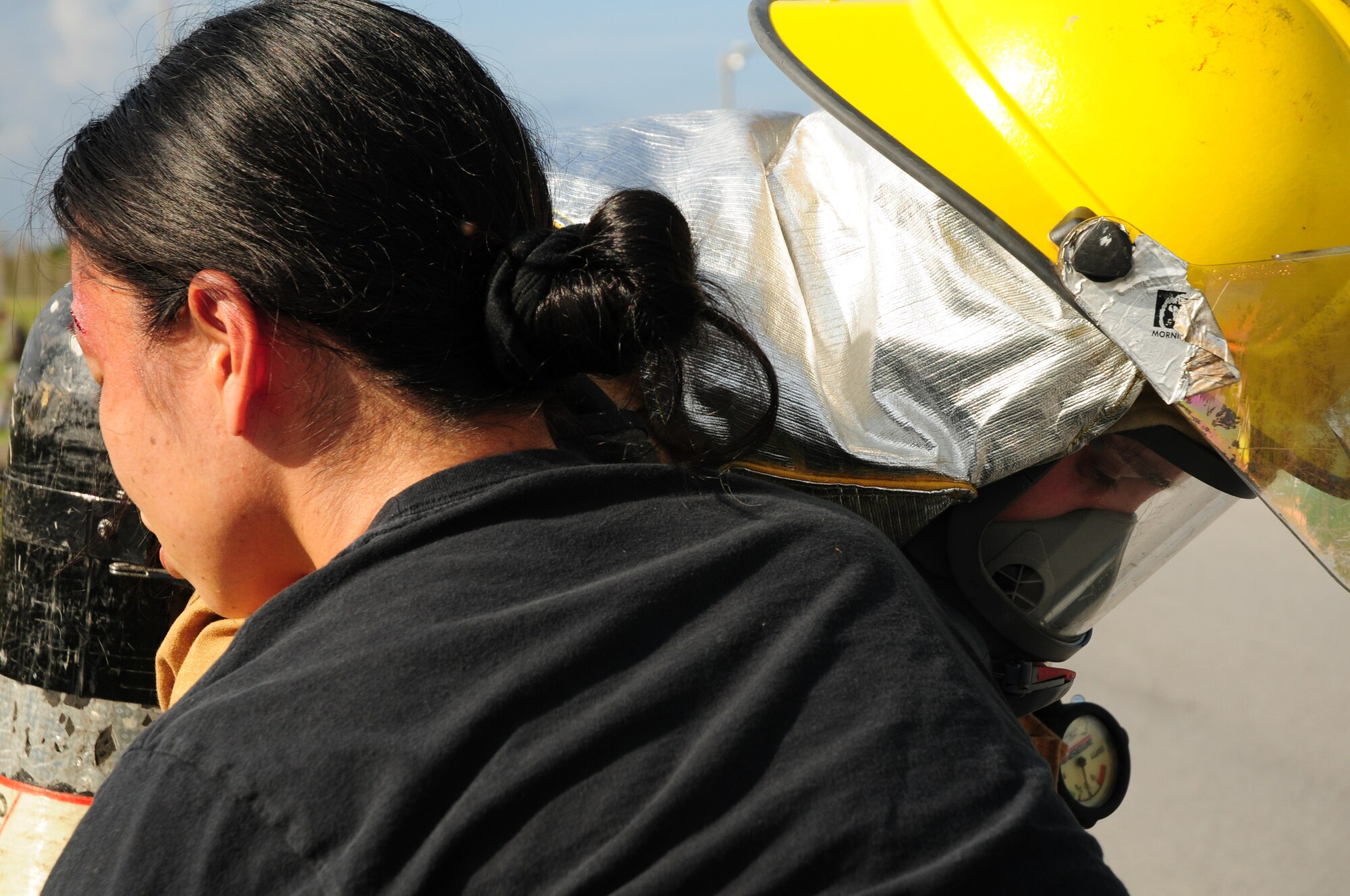 An 18th Wing firefighter carries simulated accident victim, Chikako Suzuki, to safety from a simulated car crash on Kadena Air Base Feb. 26.  The emergency management exercise honed Kadena's response capabilities.  (U.S. Air Force photo/Airman 1st Class Amanda Grabiec)