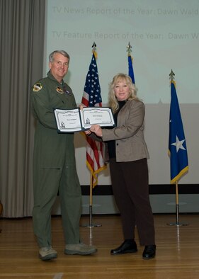 Maj. Gen. David Eichhorn (left), Air Force Flight Test Center commander, presents the Air Force Materiel Command Media Contest TV News Report (Individual) and TV Feature Report (Individual) awards to Dawn Waldman, 95th Air Base Wing Public Affairs, during a ceremony at the base theater Feb. 24. (Air Force photo by Mike Yncera)