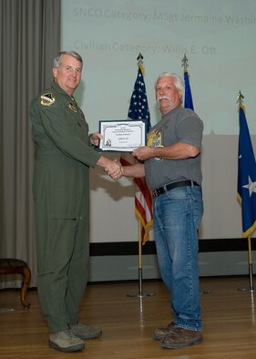 Maj. Gen. David Eichhorn (left), Air Force Flight Test Center commander, presents the Air Force Materiel Command Outstanding Munitions Civilian of the Fourth Quarter award to Willis E. Ott, 412thTest Wing, during a ceremony at the base theater Feb. 24. (Air Force photo by Mike Yncera)
