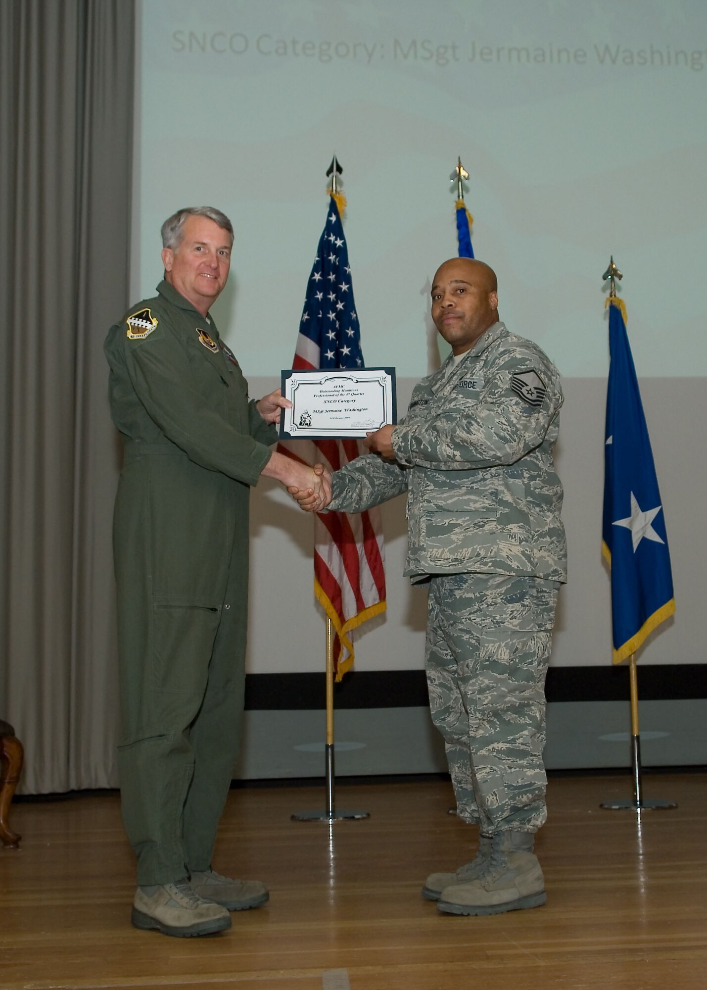 Maj. Gen. David Eichhorn (left), Air Force Flight Test Center commander, presents the Air Force Materiel Command Outstanding Munitions Senior Noncommissioned Officer of the Fourth Quarter award to Master Sgt. Jermaine Washington, 412thTest Wing, during a ceremony at the base theater Feb. 24. (Air Force photo by Mike Yncera)