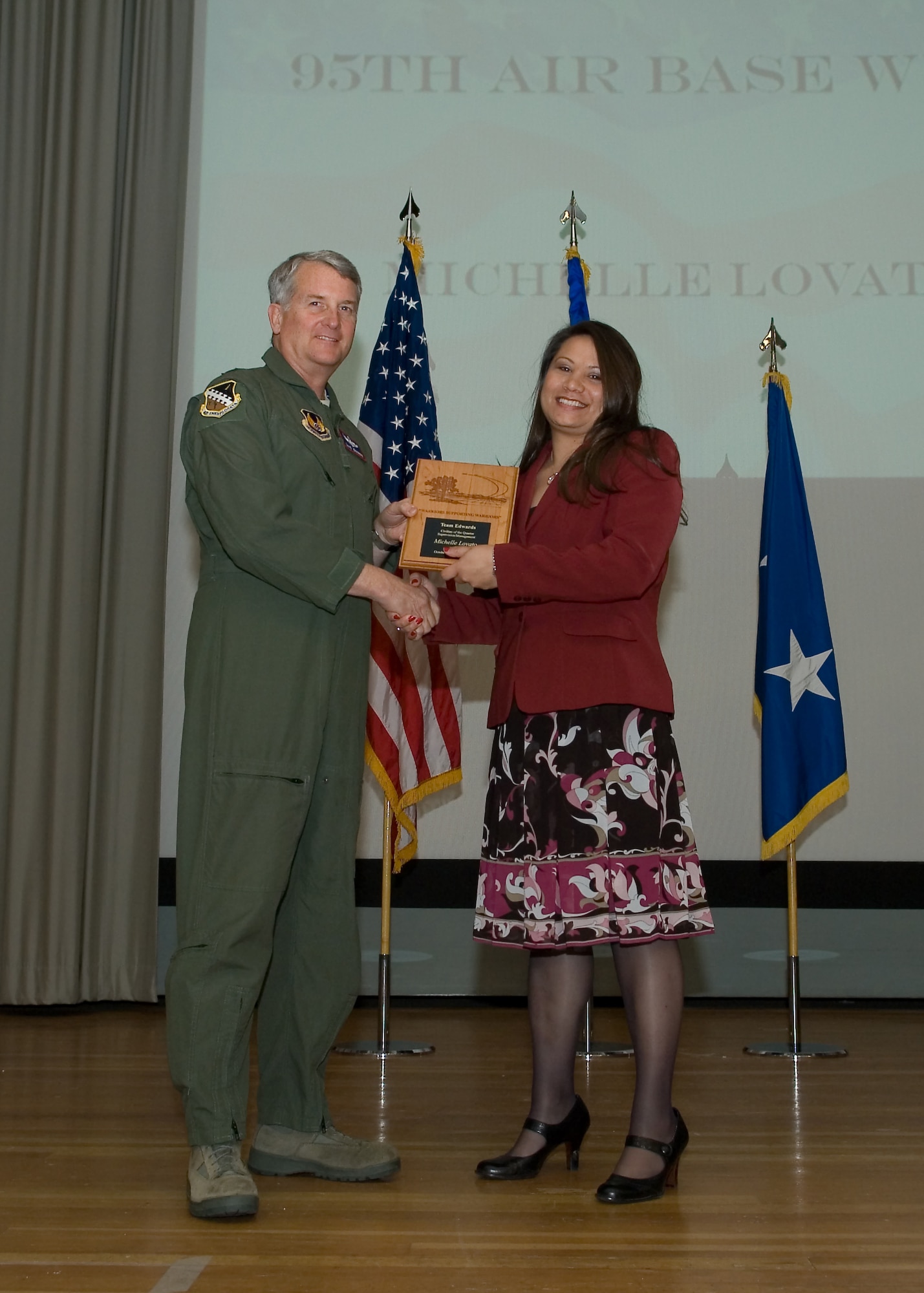 Maj. Gen. David Eichhorn (left), Air Force Flight Test Center commander, presents Michelle Lovato, 95th Force Support Squadron with Supervision and Management Civilian of the Fourth Quarter award during a ceremony at the base theater Feb. 24. (Air Force photo by Mike Yncera)
