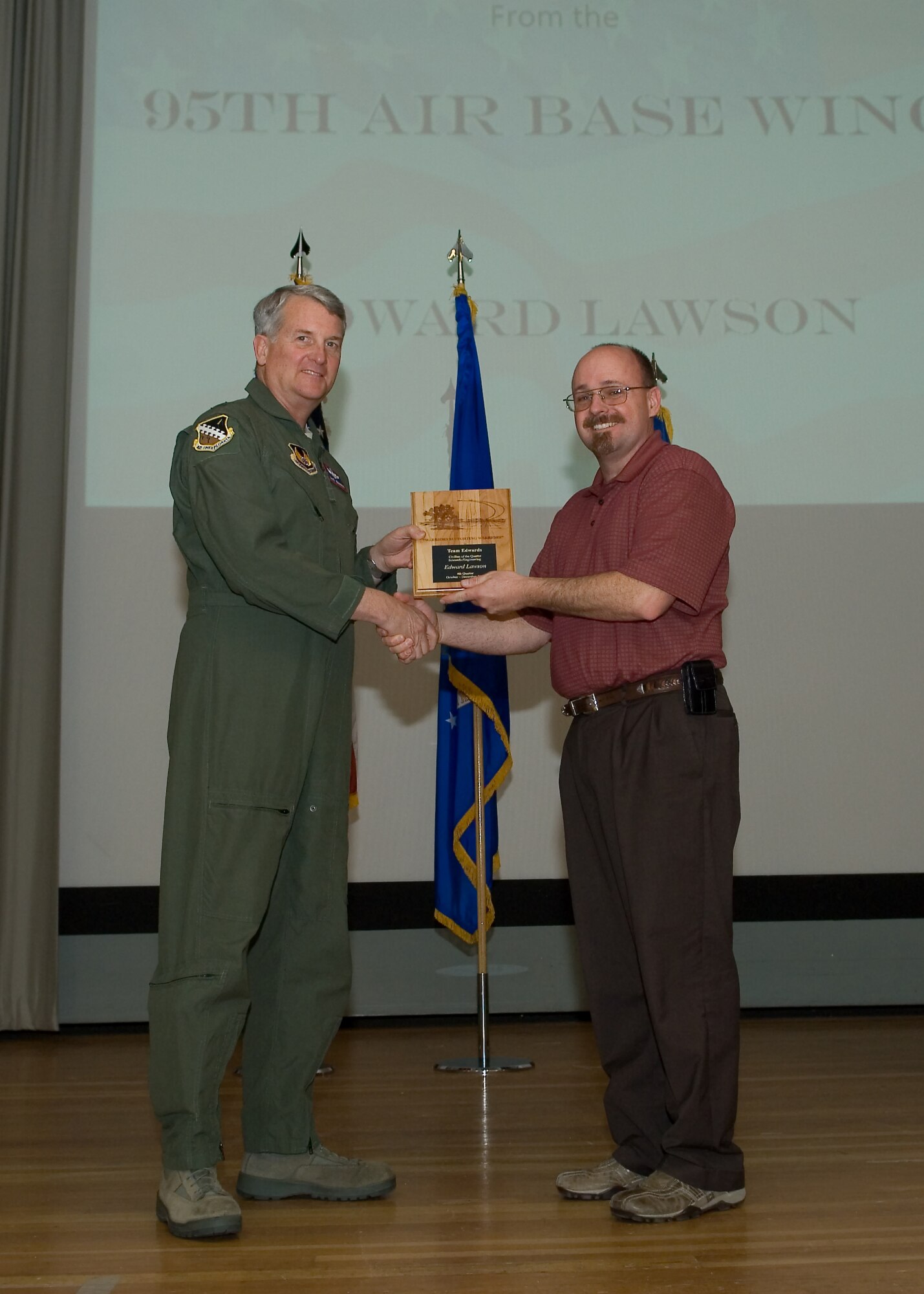 Maj. Gen. David Eichhorn (left), Air Force Flight Test Center commander, presents Edward Lawson, 95th Communications Group with the Scientific and Engineering Civilian of the Fourth Quarter award during a ceremony at the base theater Feb. 24. (Air Force photo by Mike Yncera)
