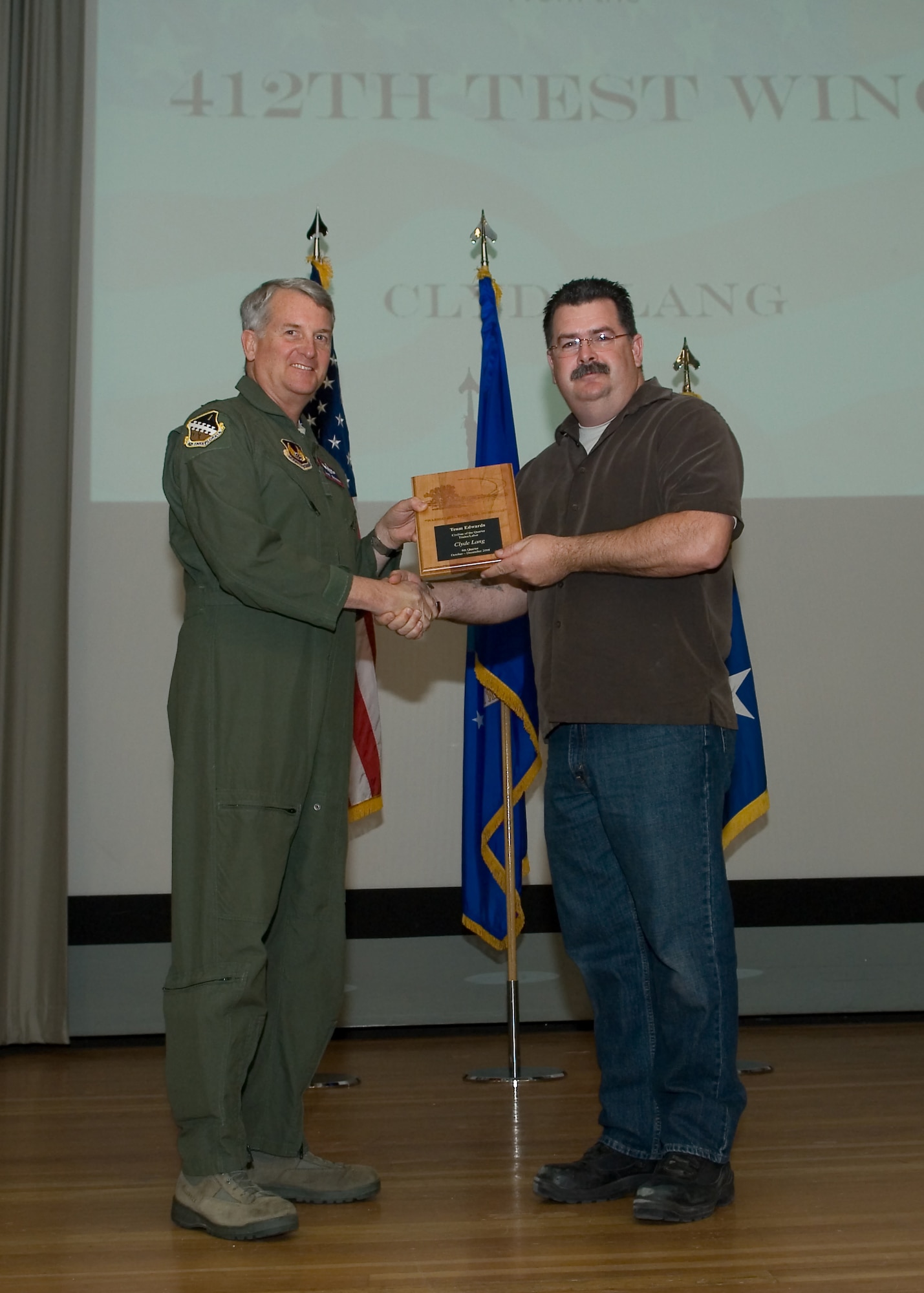 Maj. Gen. David Eichhorn (left), Air Force Flight Test Center commander, presents Clyde Lang, 912th Aircraft Maintenance Squadron with the Trades and Labor Civilian of the Fourth Quarter award during a ceremony at the base theater Feb. 24. (Air Force photo by Mike Yncera)