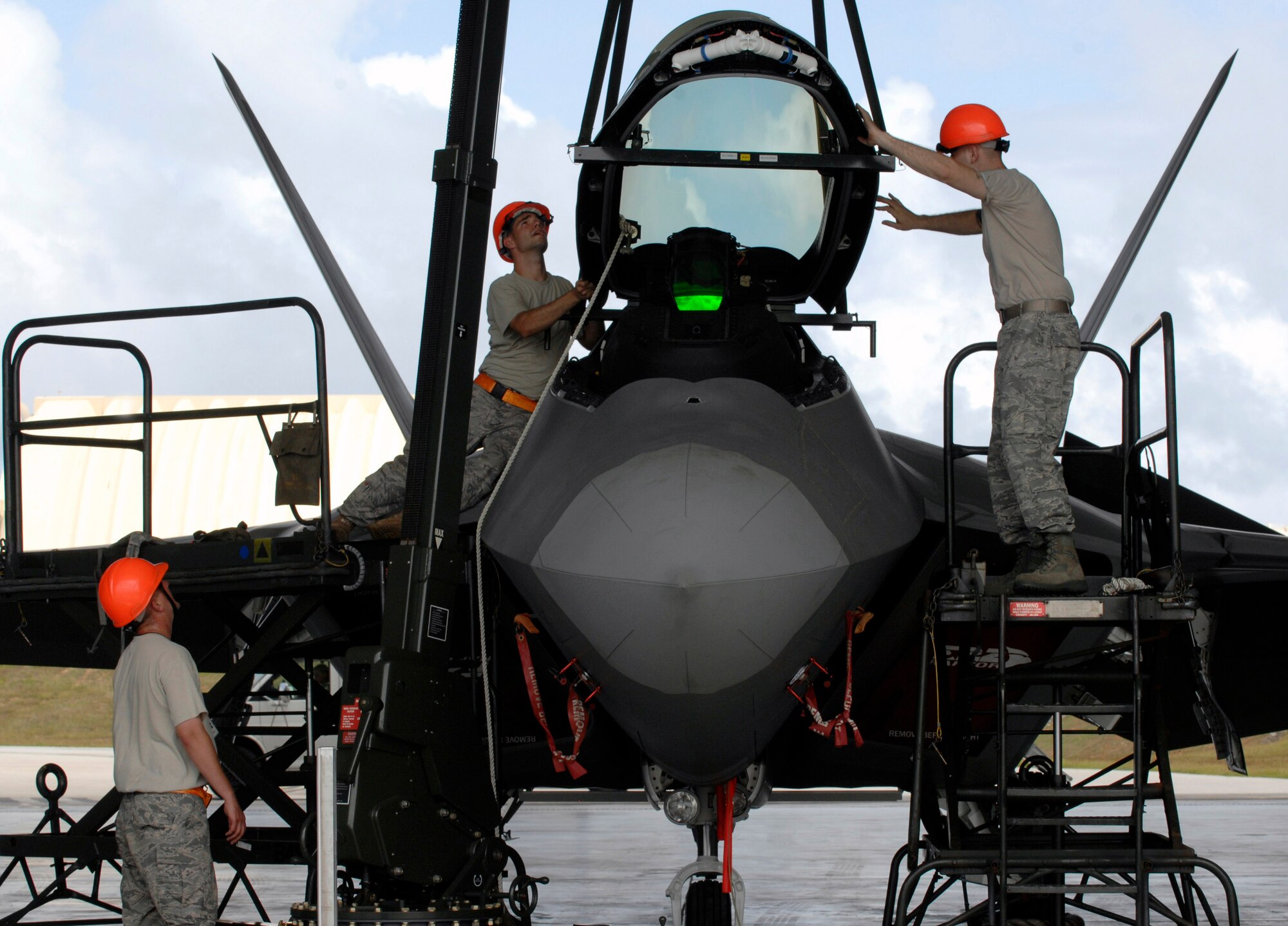 Staff Sgt. Terry Vickery (left), Staff Sgt. Tim Sullivan, and Senior Airman Ryan Ott install an F-22 Raptor canopy Feb. 18 at Andersen Air Force Base, Guam. The Raptors are deployed from Elmendorf Air Force Base, Alaska, to Guam for three months. (U.S. Air Force photo/Master Sgt. Kevin J. Gruenwald)