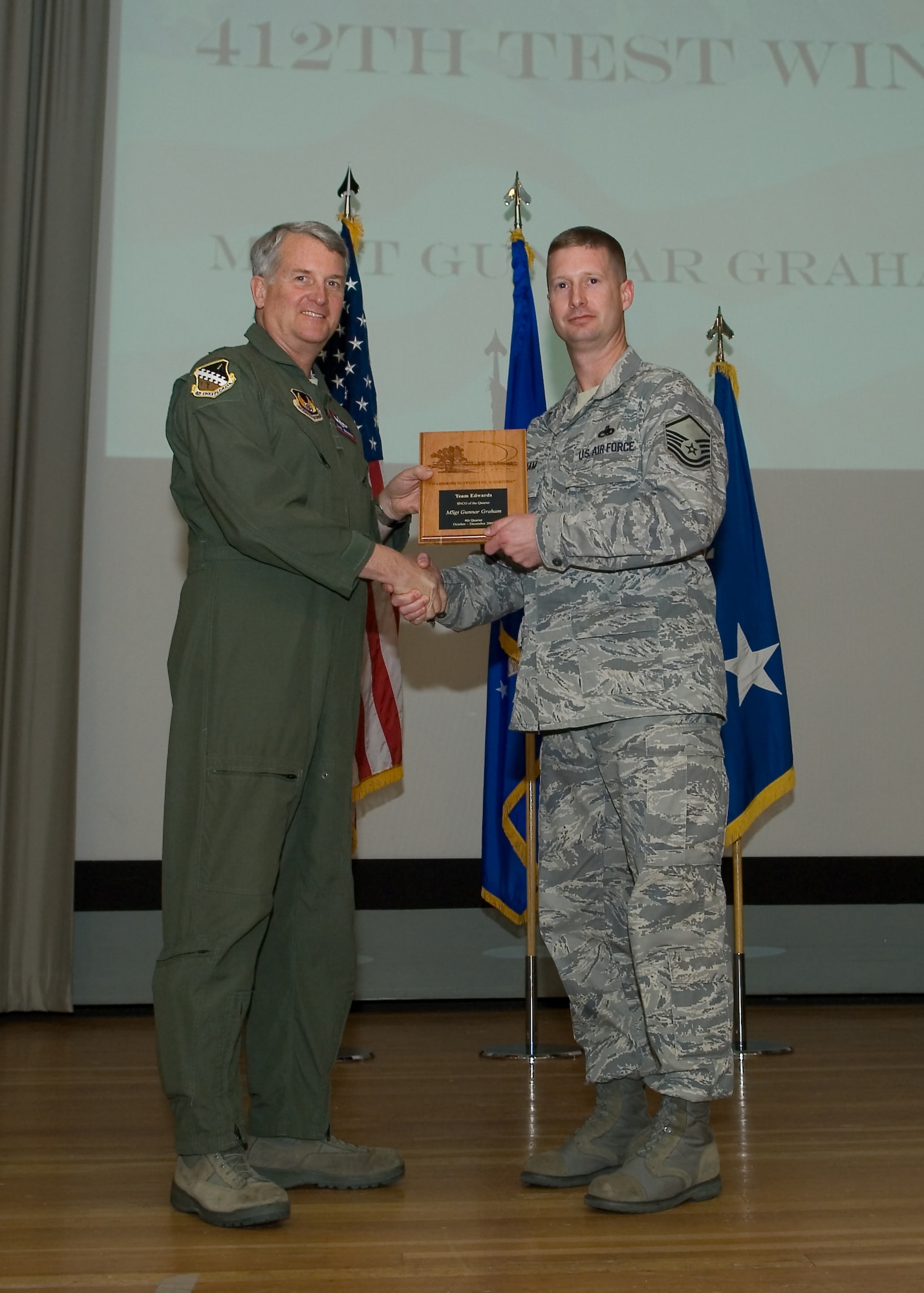 Maj. Gen. David Eichhorn (left), Air Force Flight Test Center commander, presents Master Sgt. Gunner Graham, 412th Aircraft Maintenance Squadron with the Senior Noncommissioned Officer of the Fourth Quarter award during a ceremony at the base theater Feb. 24. (Air Force photo by Mike Yncera)