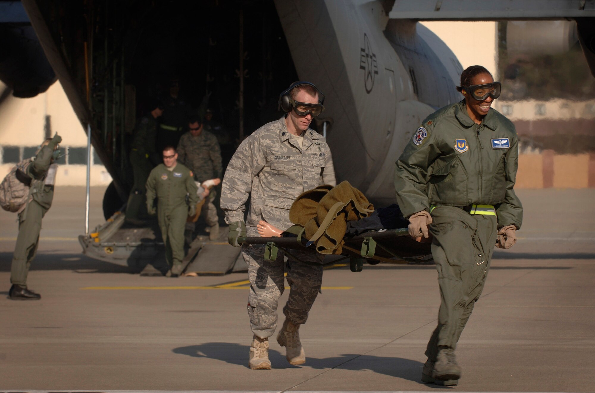 Maj. LaRhonda Gray and Colonel Grinstaff assist in an engines-running off load of 1,500 pounds of medical equipment and training mannequins following a three-hour aeromedical evacuation training sortie Feb. 19 at Ramstein Air Base, Germany. Major Gray and Colonel Grinstaff are flight nurses. (Defense Department photo/Master Sgt. Scott Wagers) 
