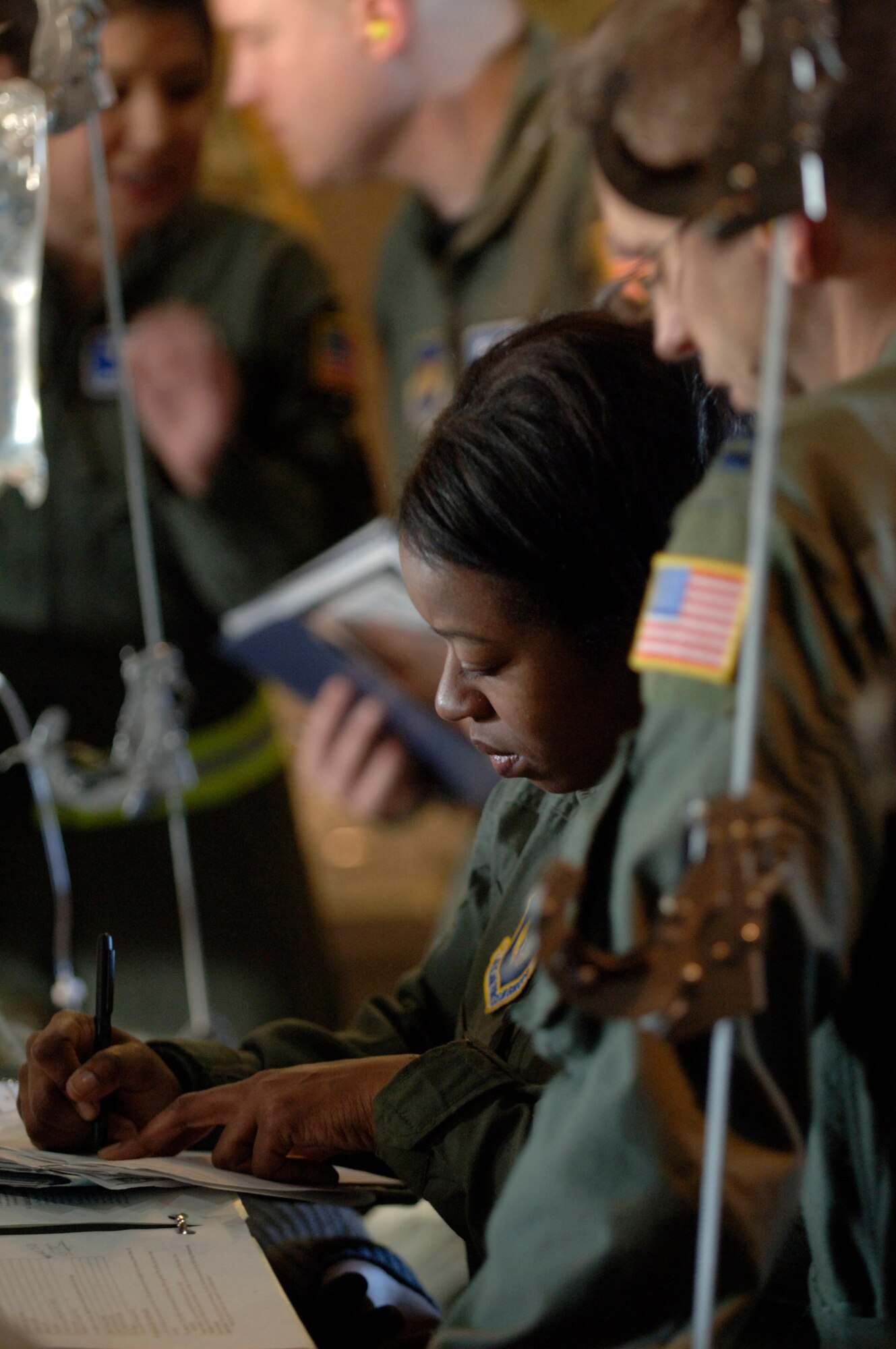 Capt. Pamela Banks records the effects of the decompression on patients while Capt. Troy Kinion looks on following a rapid decompression training scenario Feb. 19 aboard a C-130 Hercules flying over southern Germany. The flight-qualified healthcare providers, assigned to the 86th Aeromedical Evacuation Squadron, fly weekly with the 37th and 38th Airlift Squadron's C-130 fleet to remain proficient in their skills. Captain Banks is a flight nurse, and Captain Kinion is a flight nurse instructor. (Defense Department photo/Master Sgt. Scott Wagers) 
