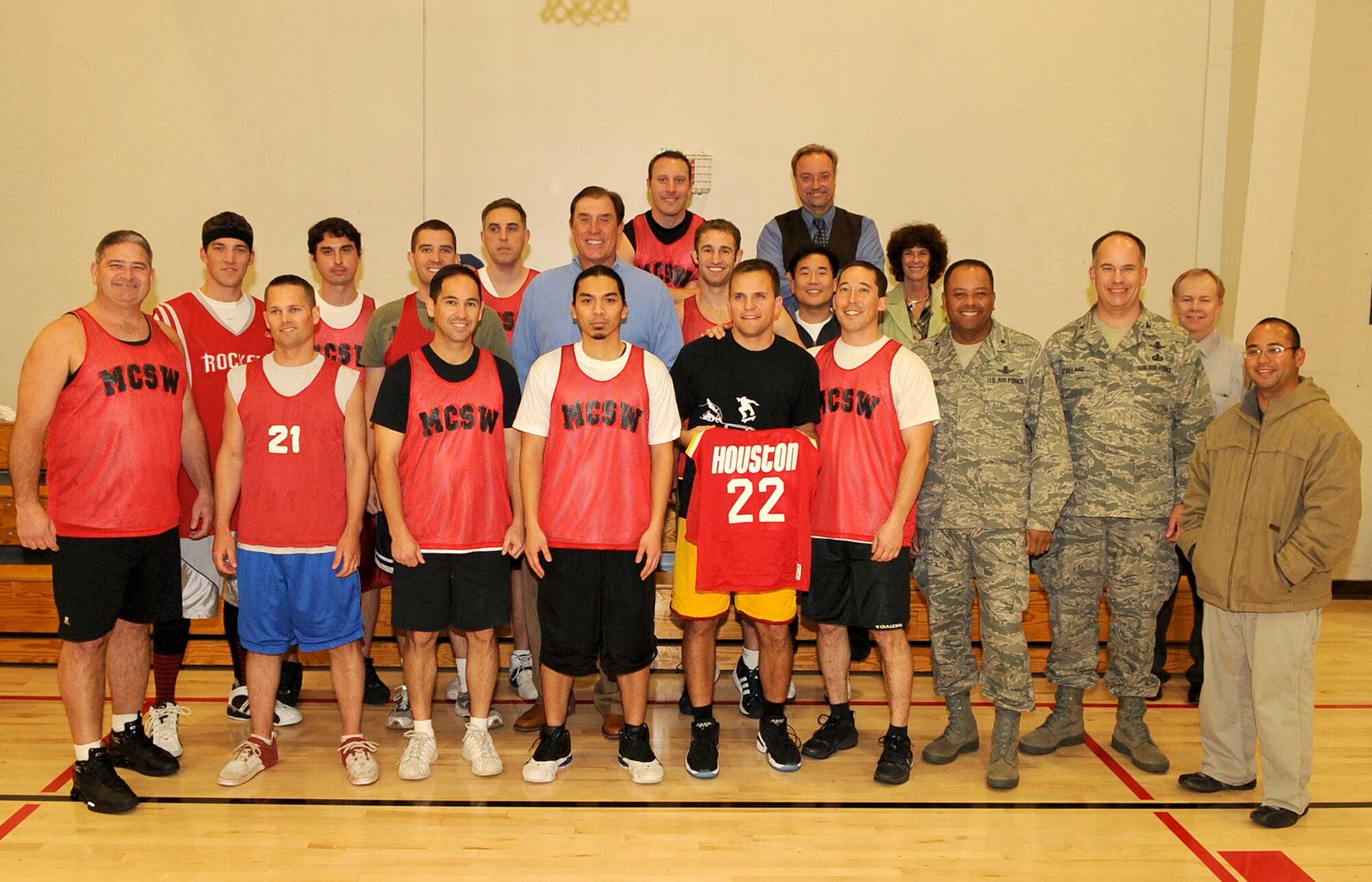 Rudy Tomjanovich (middle in blue sweater), former NBA champion, gold medal head coach of the Houston Rockets and the Men’s Basketball team for the 2000 Olympics, and former head coach of the Los Angeles Lakers, poses with team players of the Military Satellite Communications Systems Wing before their intramural basketball game, Feb. 12. Coach Tomjanovich visited the Space and Missile Center to support the troops as an invitation from his personal friend, Tom Meseroll, MILSATCOM Chief Engineer’s Office senior contractor. Brig. Gen. Samuel Greaves (front row, third from right), MILSATCOM Space Wing commander, attended the game. (Photo by Stephen Schester) (released) 