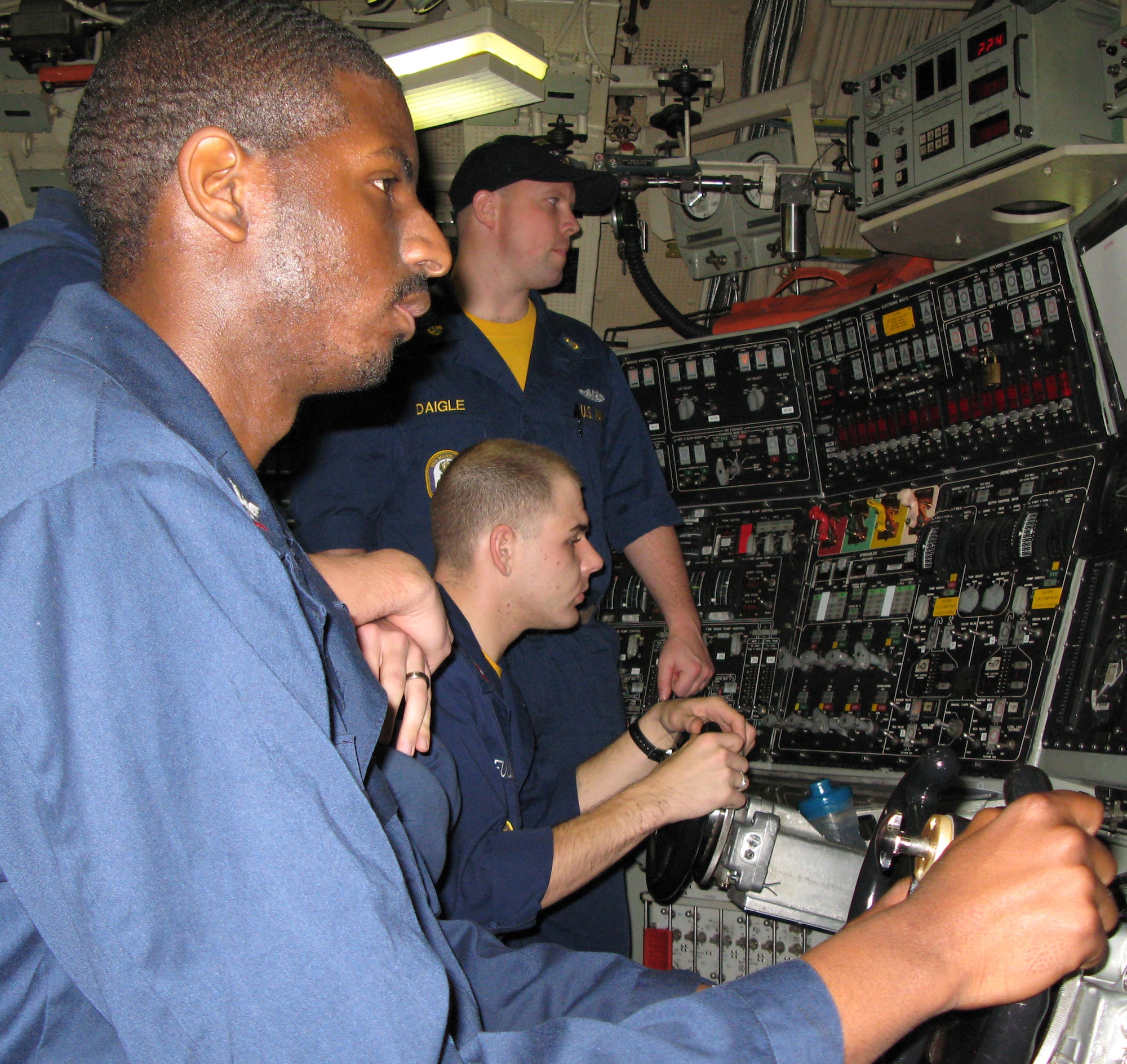 Navy Petty Officer 3rd Class Lamar Johnson uses the helmsman's controls to help pilot the strategic missile submarine USS Maryland Feb. 15 as the vessel cruises somewhere in the Atlantic Ocean.  (Department of Defense photo/Gerry J. Gilmore)