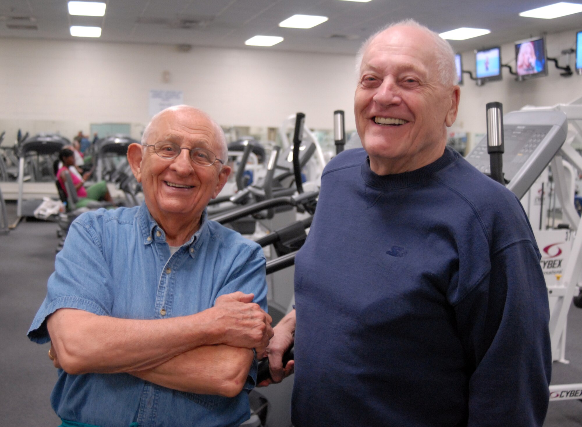 Retired Lieutenant Col. Steve Tefas (left) and retired Lt. Col. John Dierker (right) pose in front of exercise equipment at Mathis Fitness Center. (U.S. Air Force photo by Senior Master Sgt. Robert Martinez)