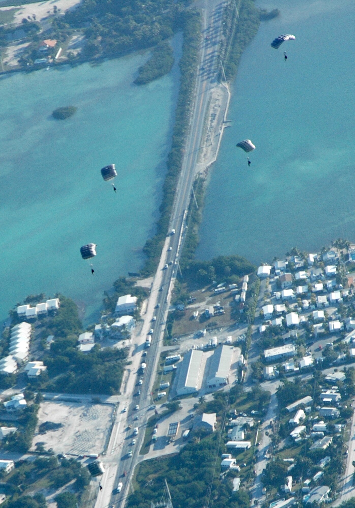 Members of U.S. Navy's Special Boat Team 20 float to earth after jumping from an Air Force Reserve Command C-130 Hercules Feb. 26, 2009, in the skies above Key West, Fla. An AF Reserve aircrew with the 302nd Airlift Wing, based at Peterson Air Force Base, Colo., supported the joint training with the Navy special forces as they performed refresher training for high-altitude, low-opening, or 'HALO' jumps. Known as Special Warfare Combatant Craft, or 'SWCCs,' the special forces members support Navy SEALs with all maritime missions, involving a variety of craft for different, specialized missions. (U.S. Air Force photo/Senior Airman Stephen Collier)