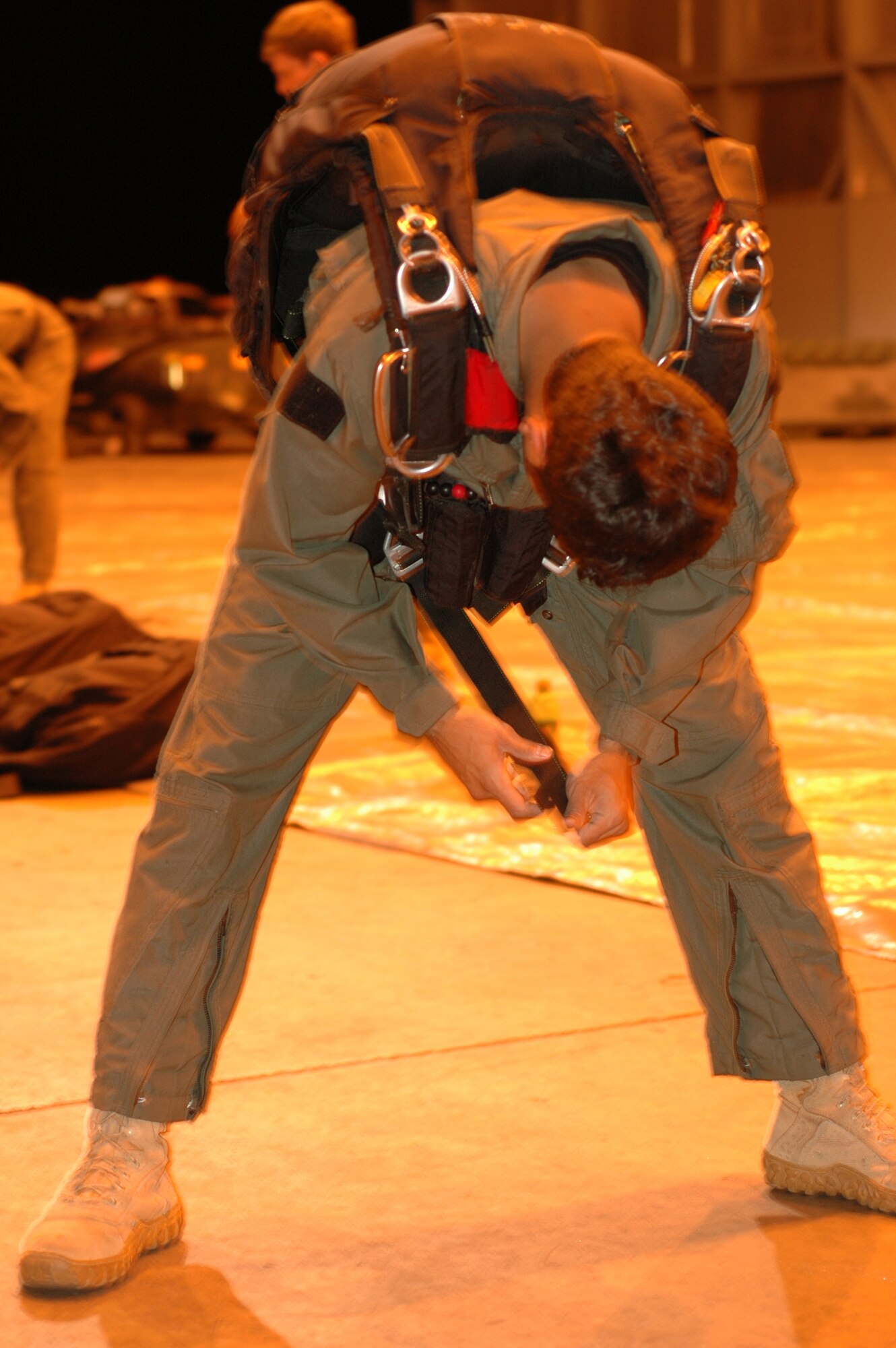 Petty Officer 3rd Class "Steven" adjusts the straps of his parachute harness before an early-morning special warfare training mission Feb. 26, 2009, at Naval Air Station Key West, Fla. Together with other members of the U.S. Navy's Special Boat Team 20, Petty Officer Steven partnered up with an Air Force Reserve Command aircrew from the 302nd Airlift Wing at Peterson Air Force Base, Colo., in support of refresher training for high-altitude, low-opening, or 'HALO' jumps. Known as Special Warfare Combatant Craft, or 'SWCCs,' the special forces members support Navy SEALs with all maritime missions, involving a variety of craft for different, specialized missions. (U.S. Air Force photo/Senior Airman Stephen Collier)