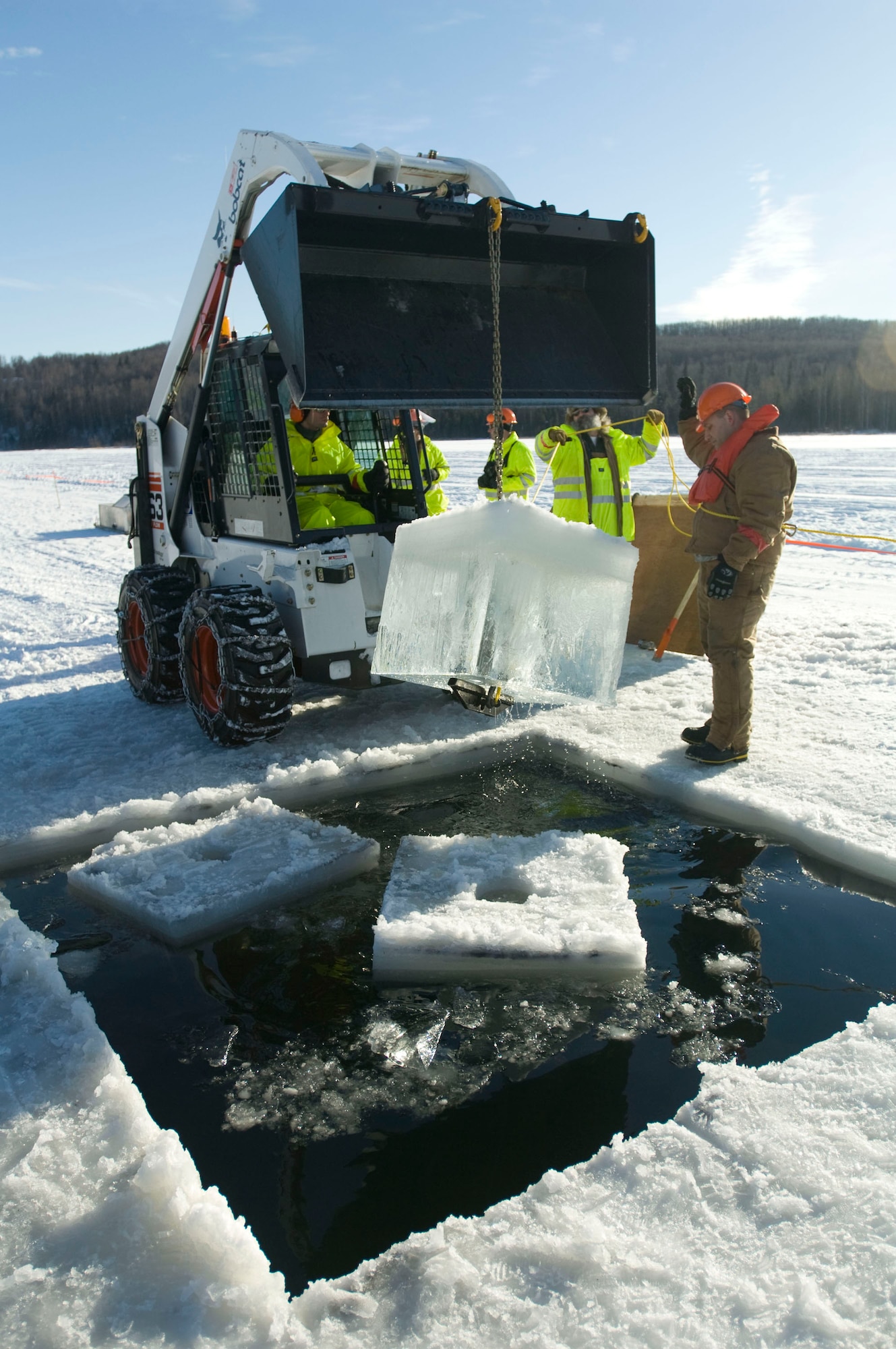 ELMENDORF AIR FORCE BASE, Alaska -- Senior Airman Jacob Smith, 611th Civil Engineer Squadron, yanks out a block of ice Feb. 24, 2009. The hole allows the oil to seep to top for collection. (U.S. Air Force photo by Senior Airman Jonathan Steffen)