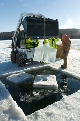 ELMENDORF AIR FORCE BASE, Alaska -- Senior Airman Jacob Smith, 611th Civil Engineer Squadron, yanks out a block of ice Feb. 24. The hole allows the oil to seep to top for collection. (U.S. Air Force photo/Senior Airman Jonathan Steffen) 