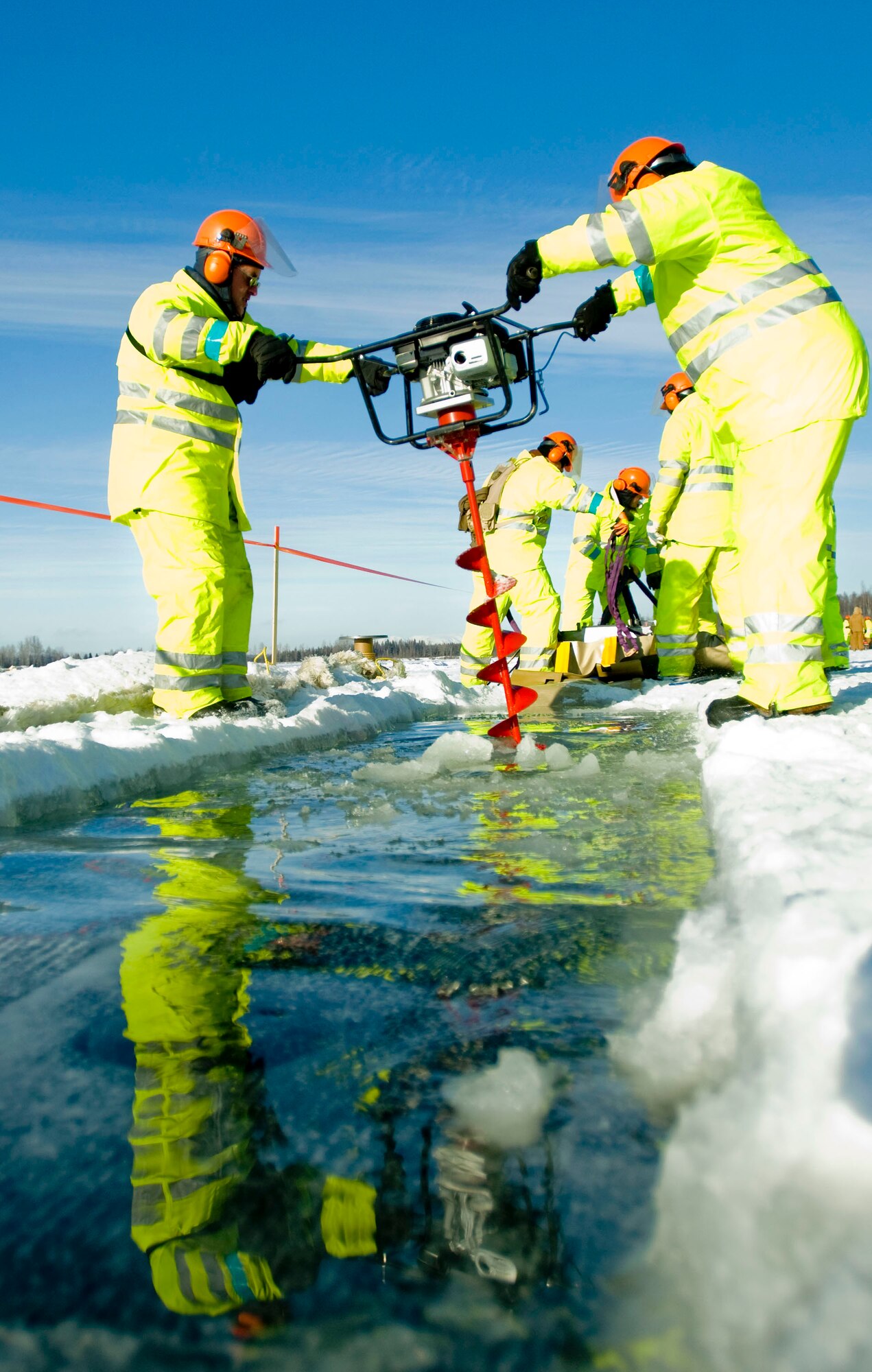 ELMENDORF AIR FORCE BASE, Alaska -- Master Sgt. James Fraser and Tech. Sgt. Eddie Campbell, 611th Civil Engineer Squadron, drills a hole in the ice with an auger Feb. 24, 2009. The 611th CES was out on Sixmile Lake to practice oil spill recovery tactics. (U.S. Air Force photo by Senior Airman Jonathan Steffen)