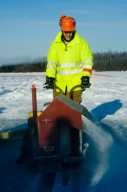 ELMENDORF AIR FORCE BASE, Alaska -- Tech. Sgt. James Crosley, 611th Civil Engineer Squadron, cuts a trench from the ice Feb. 24. The trench is used to collect oil using a mop rope. (U.S. Air Force photo/Senior Airman Jonathan Steffen)