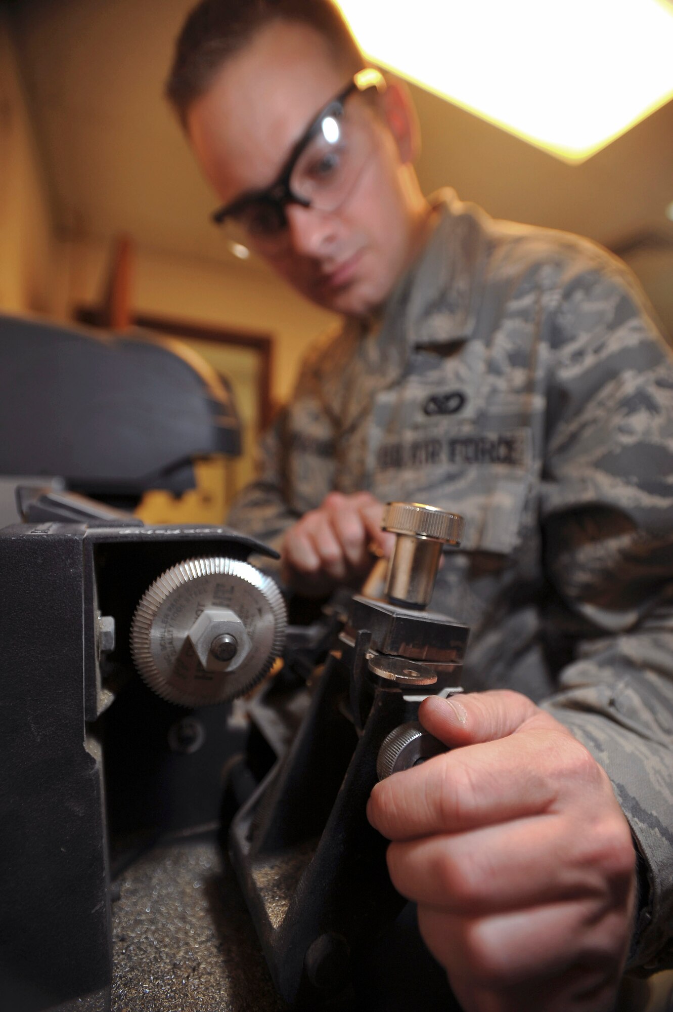Senior Airman Jesse Testudine loads and adjusts the master and blank in a key cutting machine to make a key for a customer Feb. 25 at an air base in Southwest Asia. Airman Testudine and fellow locksmiths make an estimatedn 430 keys a month for new personnel, new building structures and to replace lost keys. Airman Testudine is a locksmith with the 379th Expeditionary Civil Engineer Squadron, and is deployed from Misawa Air Base, Japan.  (U.S. Air Force photo/Staff Sgt. Joshua Garcia) 
