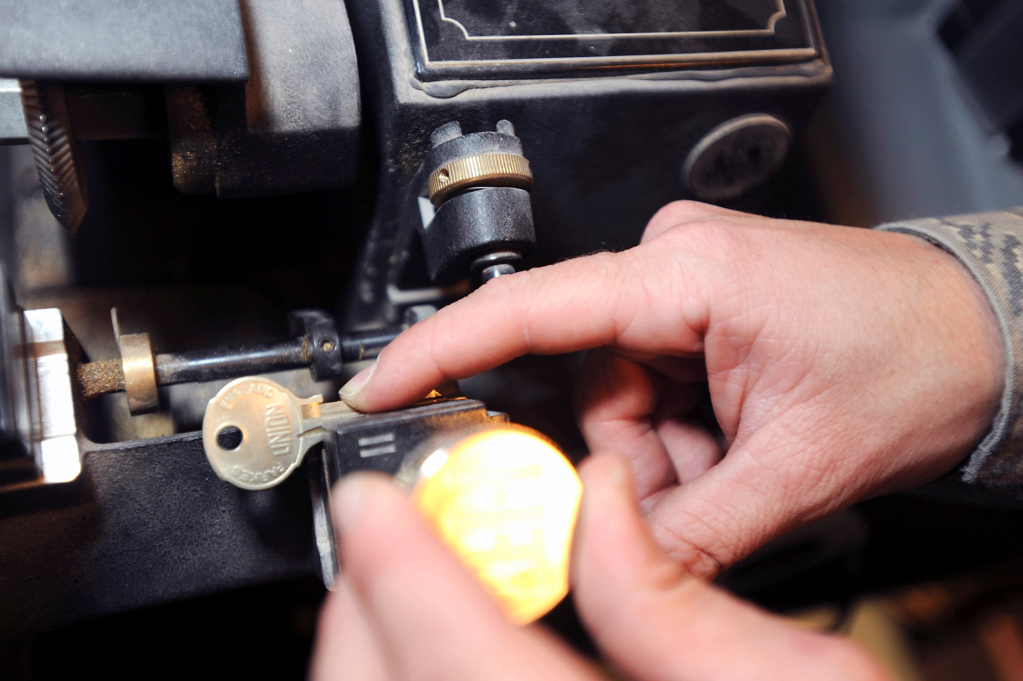 Senior Airman Jesse Testudine adjusts the master key in a key cutting machine to make a key for a customer Feb. 25 at an air base in Southwest Asia. He is a locksmith with the 379th Expeditionary Civil Engineer Squadron, and is deployed from Misawa Air Base, Japan.  (U.S. Air Force photo/Staff Sgt. Joshua Garcia) 
