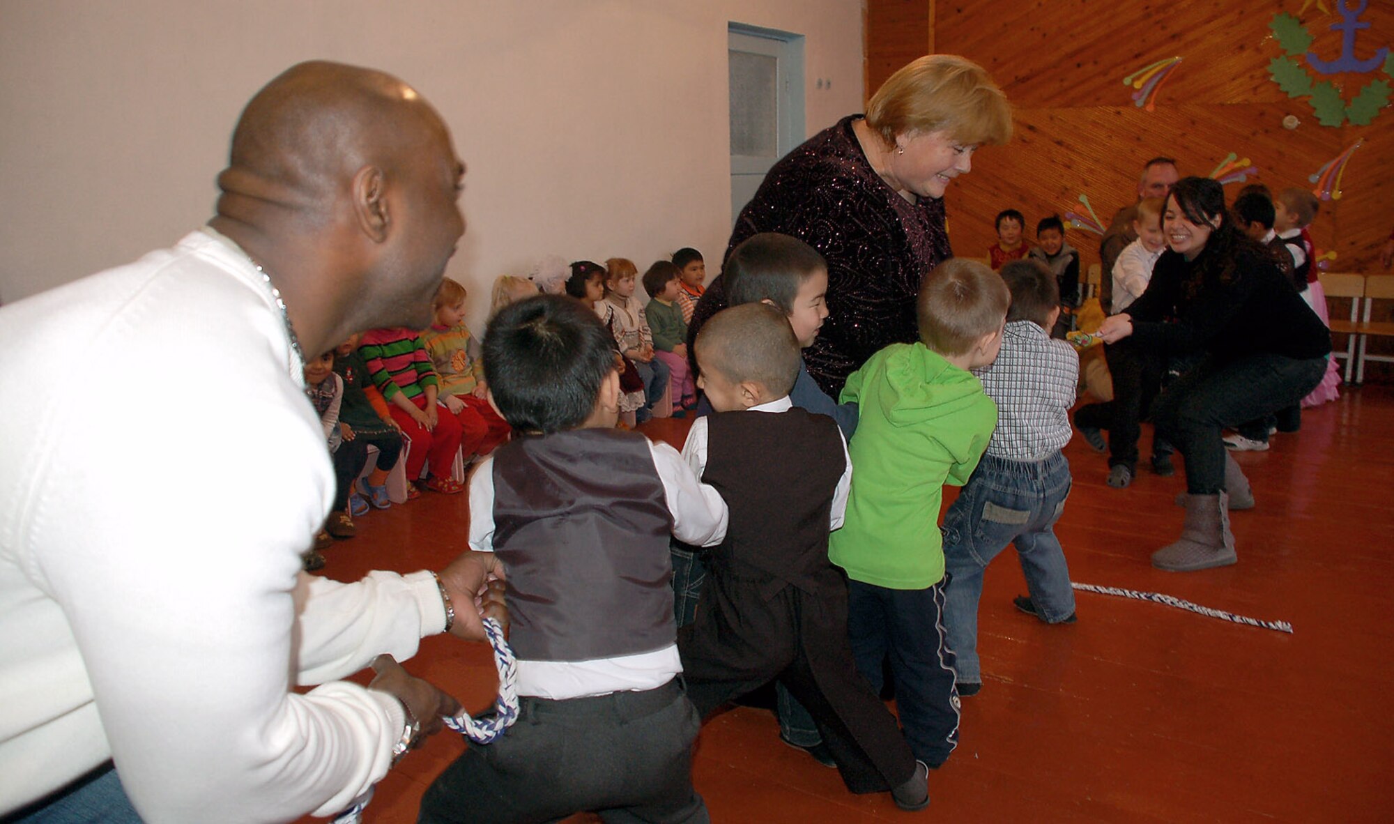 Staff Sgt. Chris Moore serves as anchor for a tug-of-war game with kindergarteners during a Feb. 20 celebration at the Vasilievka Kindergarten School in Kyrgyzstan. More than 75 children put on a special performance for volunteers from nearby Manas Air Base, Kyrgyzstan, to thank them for their support in helping rebuild their school over the past seven years. Sergeant Moore is assigned to the 376th Air Expeditionary Wing staff. (U.S. Air Force photo/Tech. Sgt. Phyllis Hanson) 
