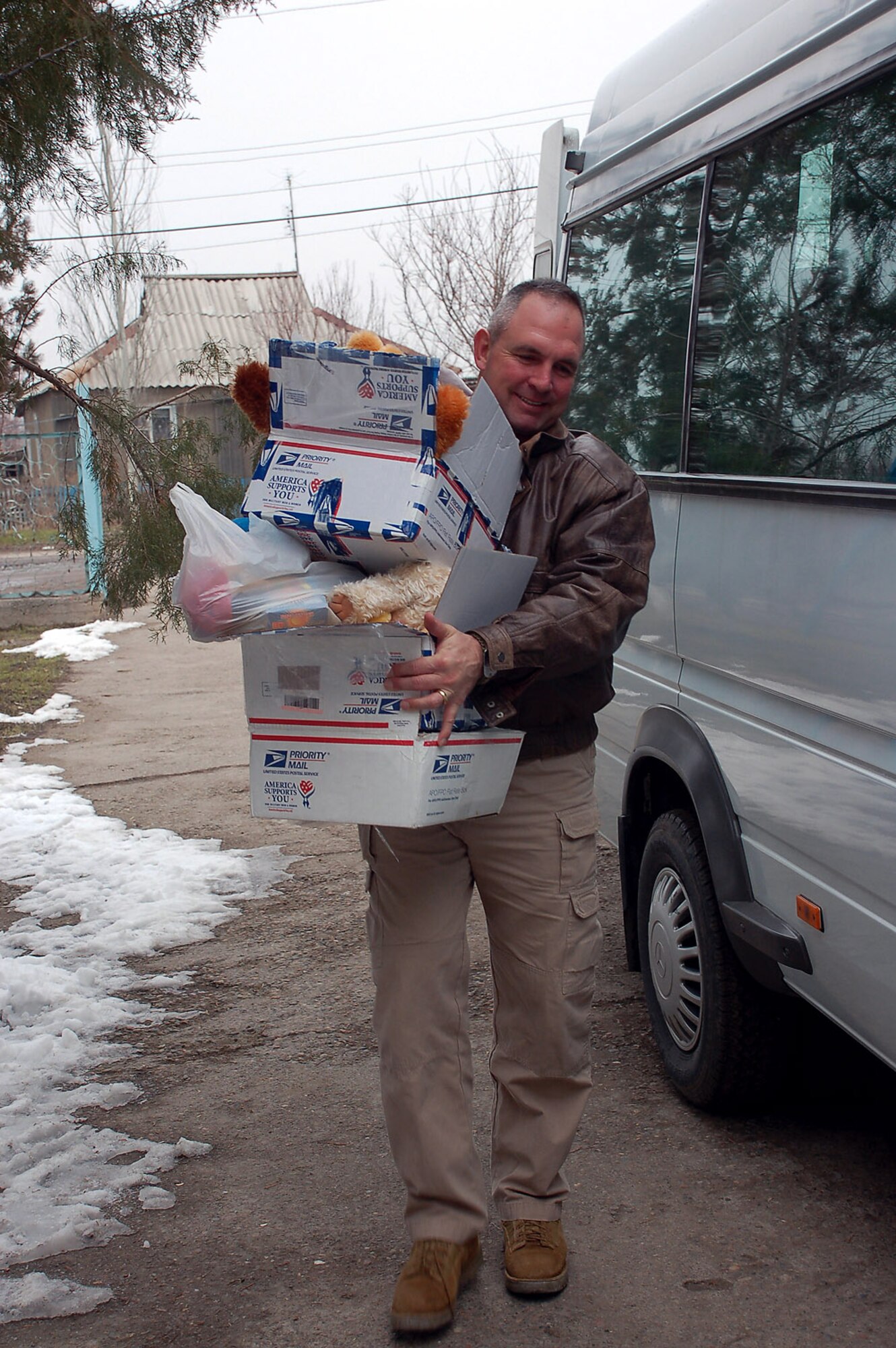 Tech. Sgt. Chad West carries care packages full of toys and school supplies for children Feb. 20 at the Vasilievka Kindergarten School in Vinogradnoye Village. Sergeant West and other volunteer Airmen from the 376th Expeditionary Operations Group and the Air Expeditionary Wing staff at Manas Air Base, Kyrgyzstan, recently delivered a new generator, refrigerator and stove to the school through the Manas Service Organization. Sergeant West is deployed with the 376th Expeditionary Security Forces Squadron deployed from the Arkansas Air National Guard at Fort Smith. (U.S. Air Force photo/Tech. Sgt. Phyllis Hanson) 
